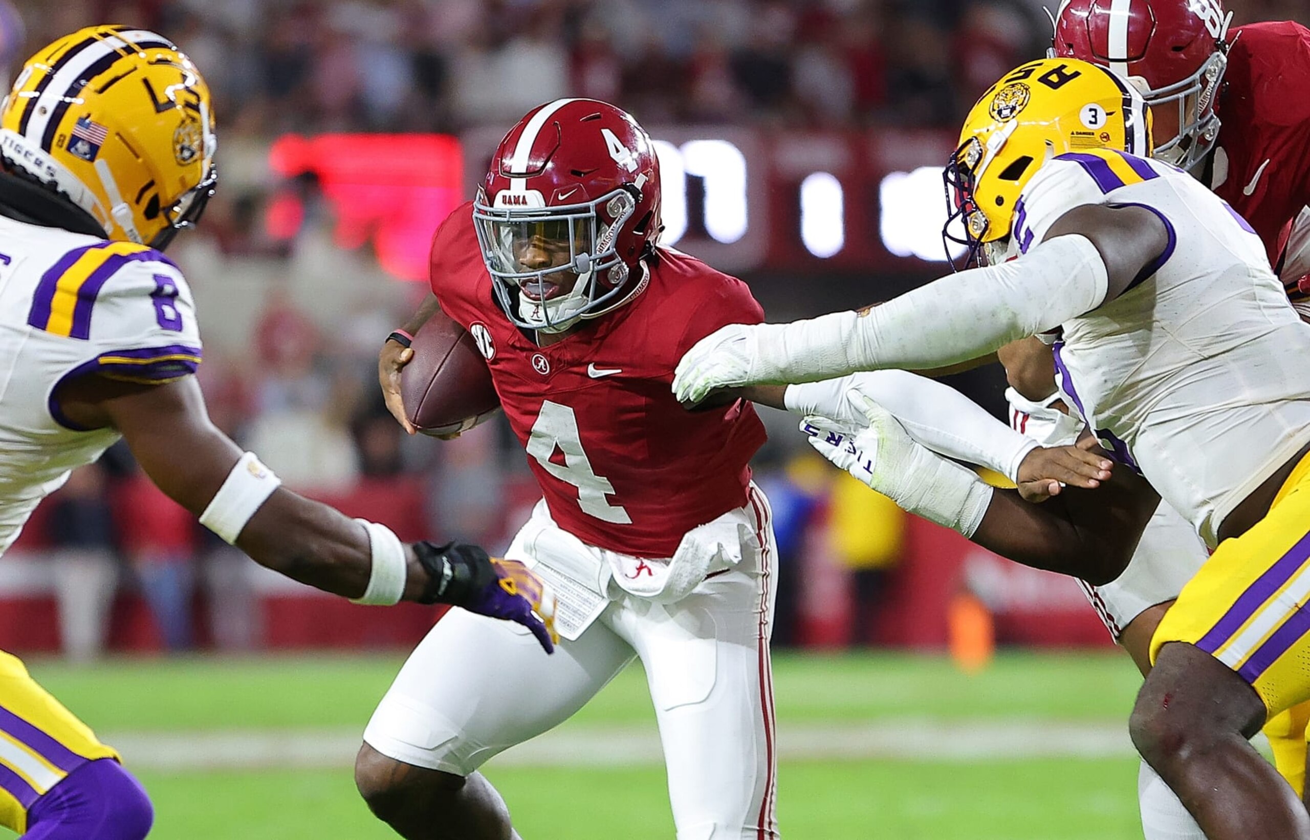 TUSCALOOSA, ALABAMA - NOVEMBER 04:  Jalen Milroe #4 of the Alabama Crimson Tide rushes against Ovie Oghoufo #2 and Major Burns #8 of the LSU Tigers during the first quarter at Bryant-Denny Stadium on November 04, 2023 in Tuscaloosa, Alabama.  (Photo by Kevin C. Cox/Getty Images)