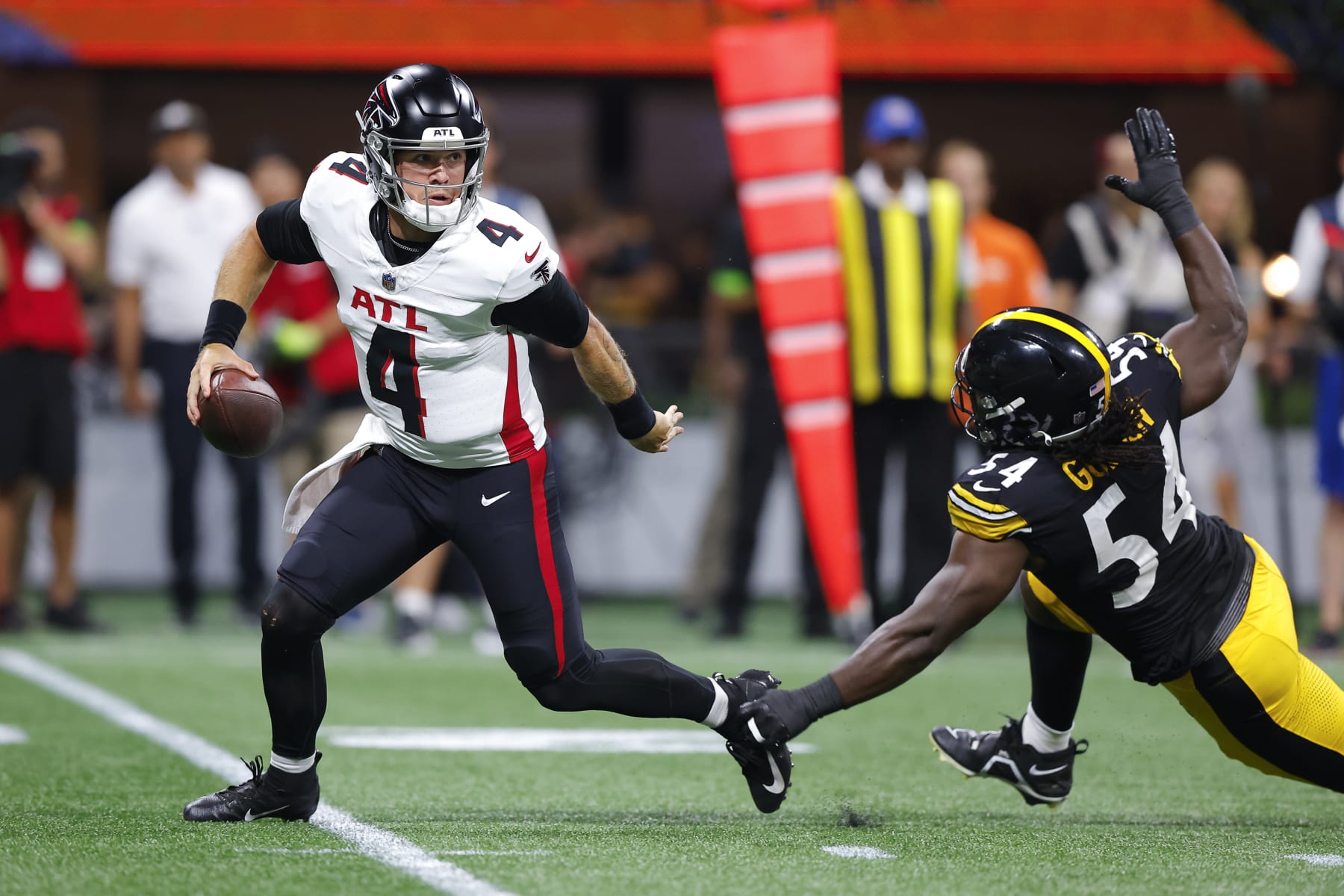 ATLANTA, GEORGIA - AUGUST 24: Taylor Heinicke #4 of the Atlanta Falcons is pressured by Markus Golden #54 of the Pittsburgh Steelers during the first quarter of a preseason game at Mercedes-Benz Stadium on August 24, 2023 in Atlanta, Georgia. (Photo by Todd Kirkland/Getty Images)
