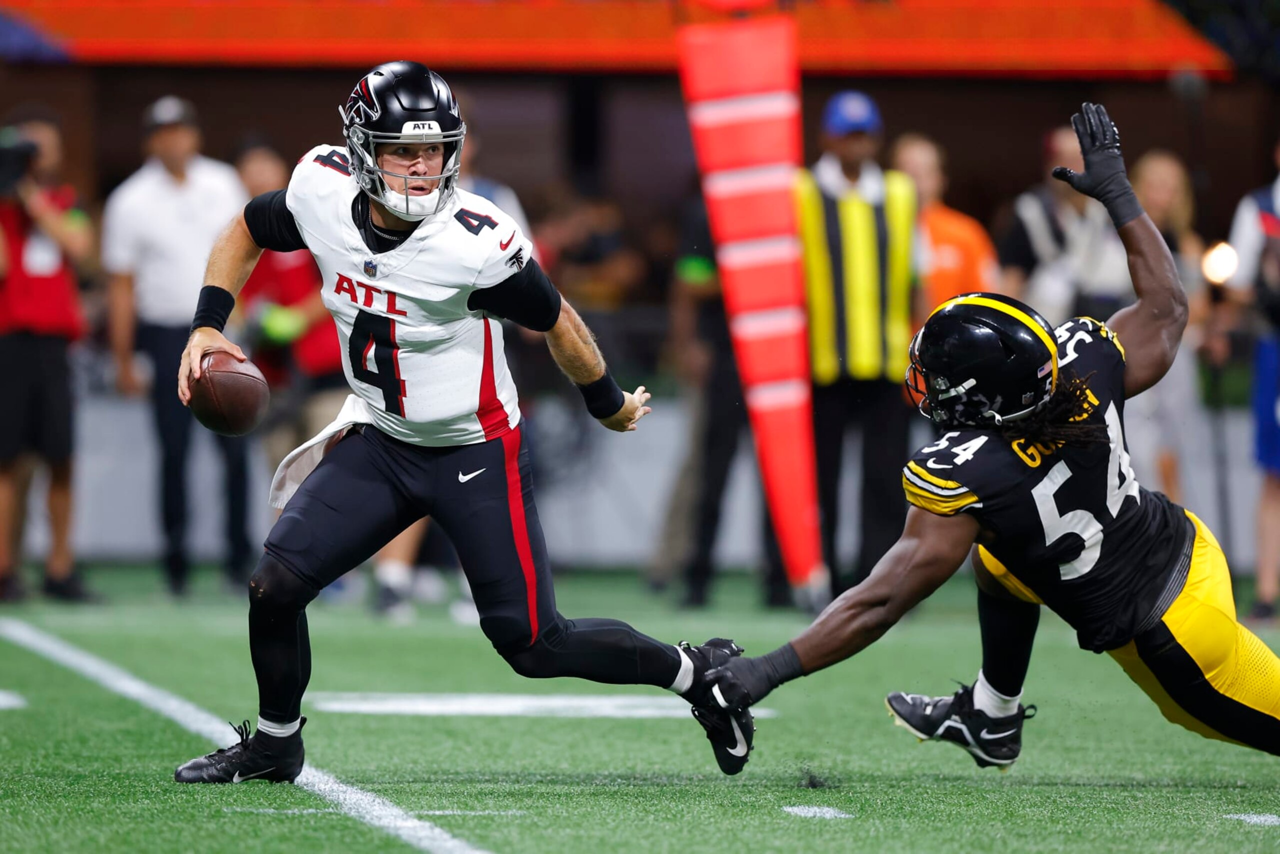 ATLANTA, GEORGIA - AUGUST 24: Taylor Heinicke #4 of the Atlanta Falcons is pressured by Markus Golden #54 of the Pittsburgh Steelers during the first quarter of a preseason game at Mercedes-Benz Stadium on August 24, 2023 in Atlanta, Georgia. (Photo by Todd Kirkland/Getty Images)