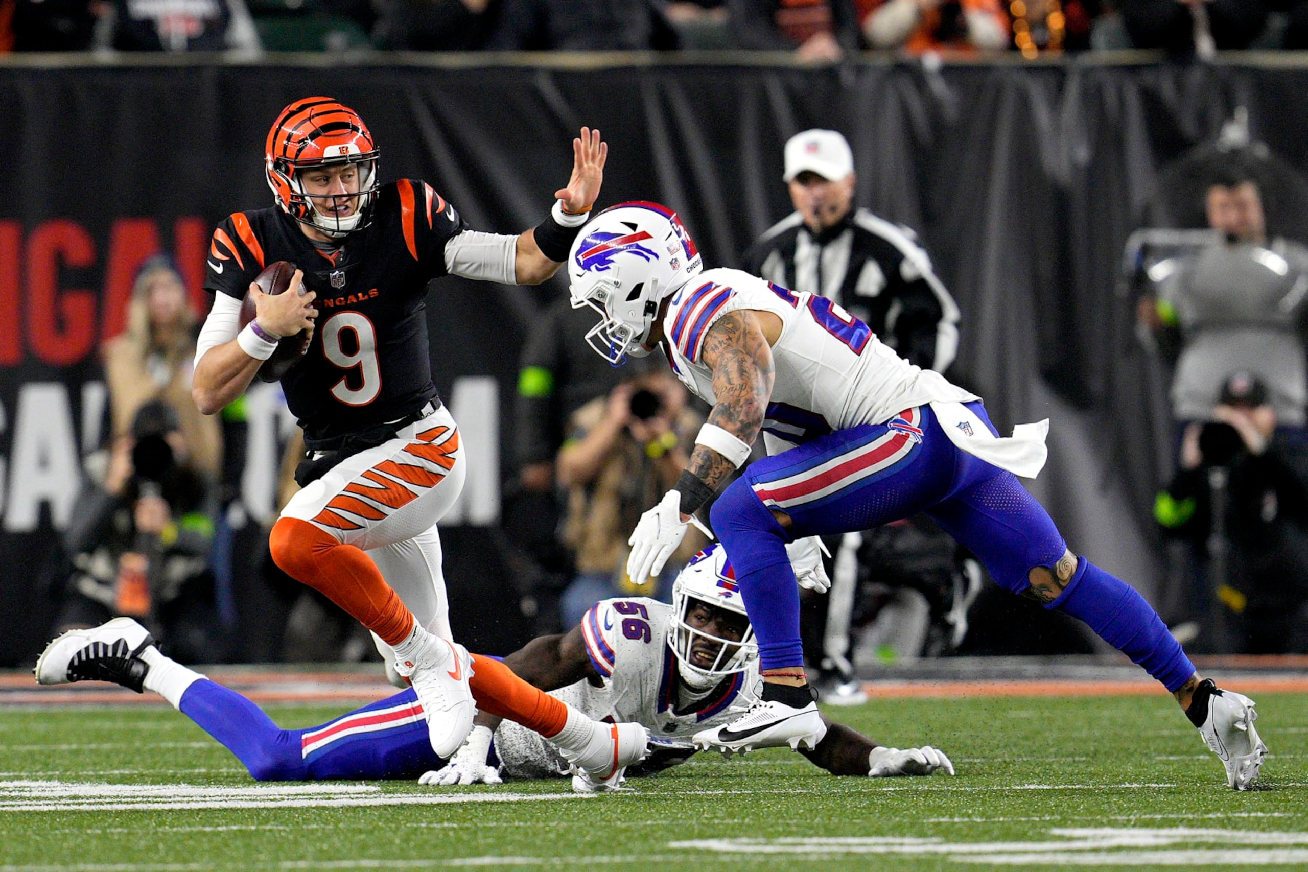 CINCINNATI, OHIO - NOVEMBER 05:  Joe Burrow #9 of the Cincinnati Bengals carries the ball against Taylor Rapp #20 of the Buffalo Bills during the third quarter at Paycor Stadium on November 05, 2023 in Cincinnati, Ohio. (Photo by Jeff Dean/Getty Images)