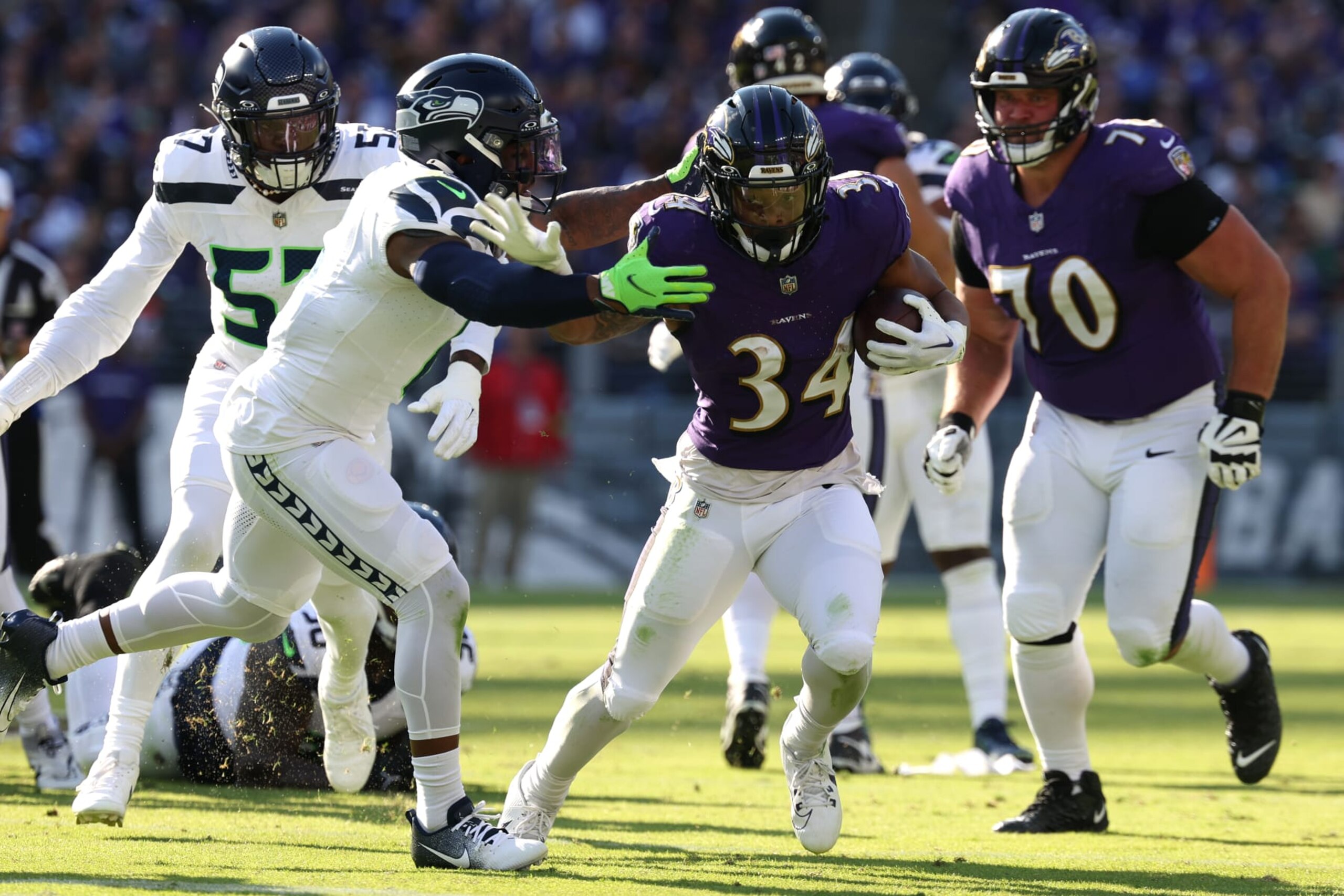 BALTIMORE, MARYLAND - NOVEMBER 05: Keaton Mitchell #34 of the Baltimore Ravens is tackled by Derick Hall #58 of the Seattle Seahawks during the first half at M&T Bank Stadium on November 05, 2023 in Baltimore, Maryland. (Photo by Patrick Smith/Getty Images)