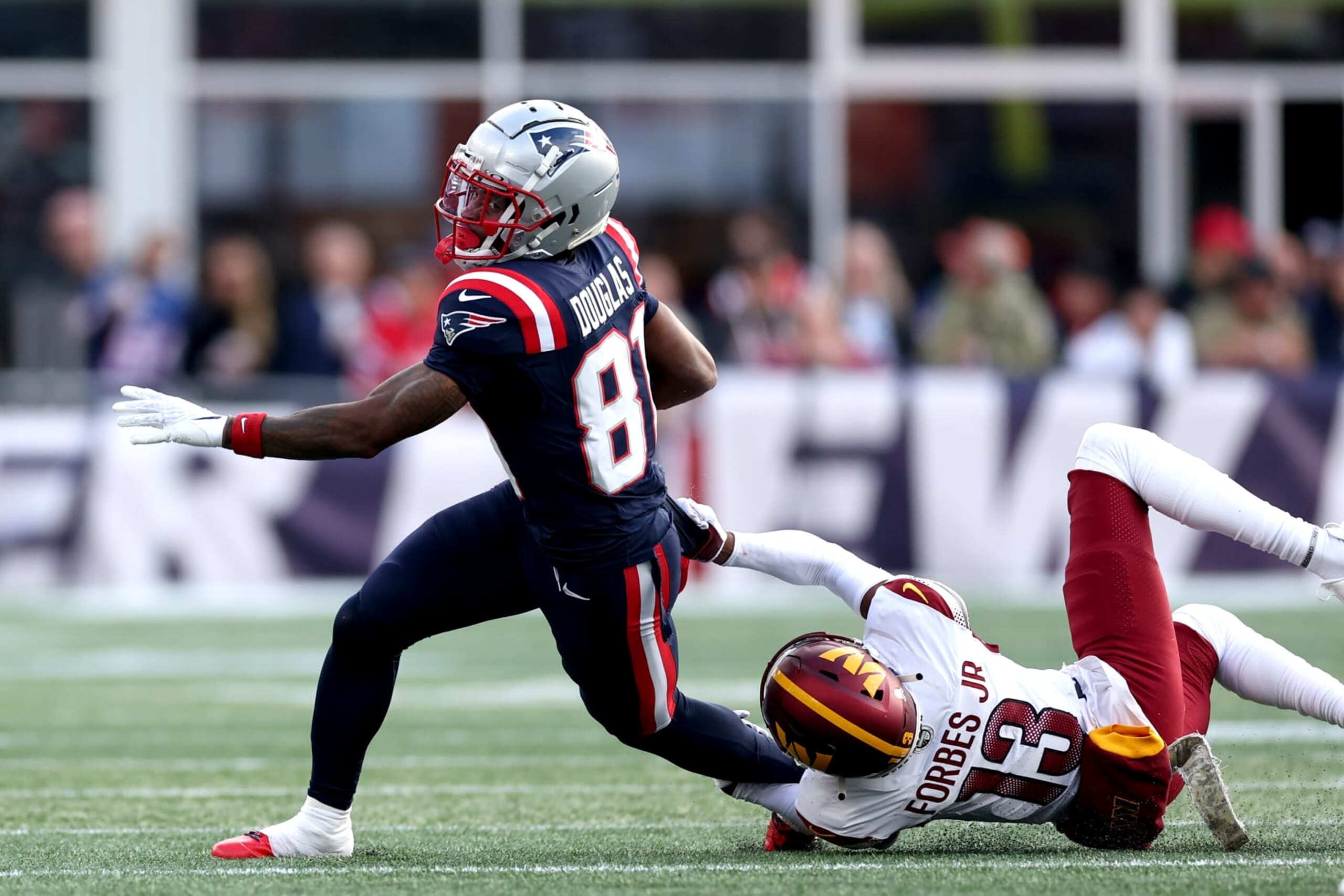 FOXBOROUGH, MASSACHUSETTS - NOVEMBER 05: Demario Douglas #81 of the New England Patriots is tackled by Emmanuel Forbes #13 of the Washington Commanders during the second half at Gillette Stadium on November 05, 2023 in Foxborough, Massachusetts. (Photo by Maddie Meyer/Getty Images) FOXBOROUGH, MASSACHUSETTS - NOVEMBER 05: Demario Douglas #81 of the New England Patriots is tackled by Emmanuel Forbes #13 of the Washington Commanders during the second half at Gillette Stadium on November 05, 2023 in Foxborough, Massachusetts. (Photo by Maddie Meyer/Getty Images)