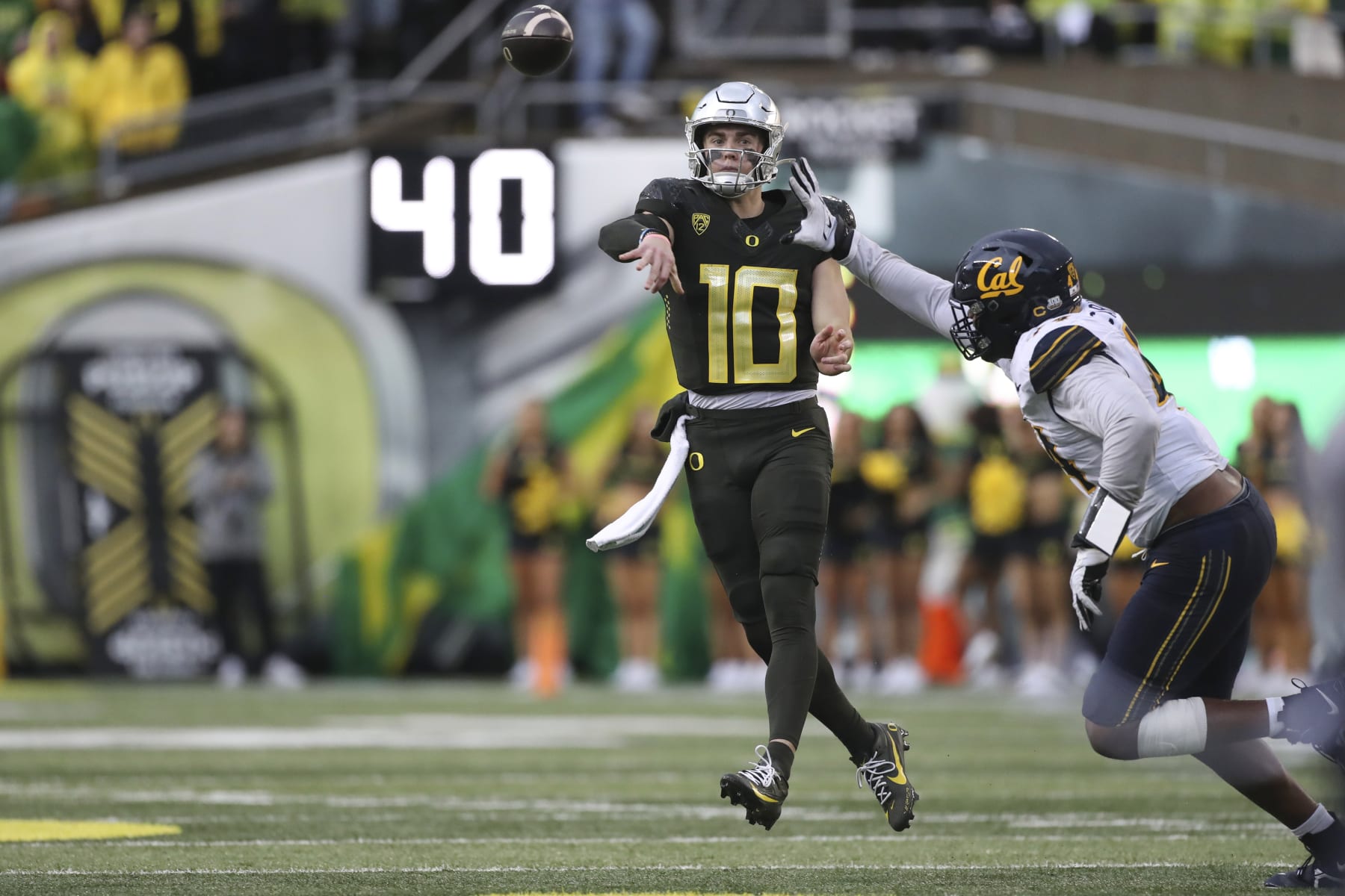Oregon quarterback Bo Nix (10) throws a pass as California linebacker Xavier Carlton, right, defends during the first half of an NCAA football game, Saturday, Nov. 4, 2023, in Eugene, Ore. (AP Photo/Amanda Loman) Oregon quarterback Bo Nix (10) throws a pass as California linebacker Xavier Carlton, right, defends during the first half of an NCAA football game, Saturday, Nov. 4, 2023, in Eugene, Ore. (AP Photo/Amanda Loman)