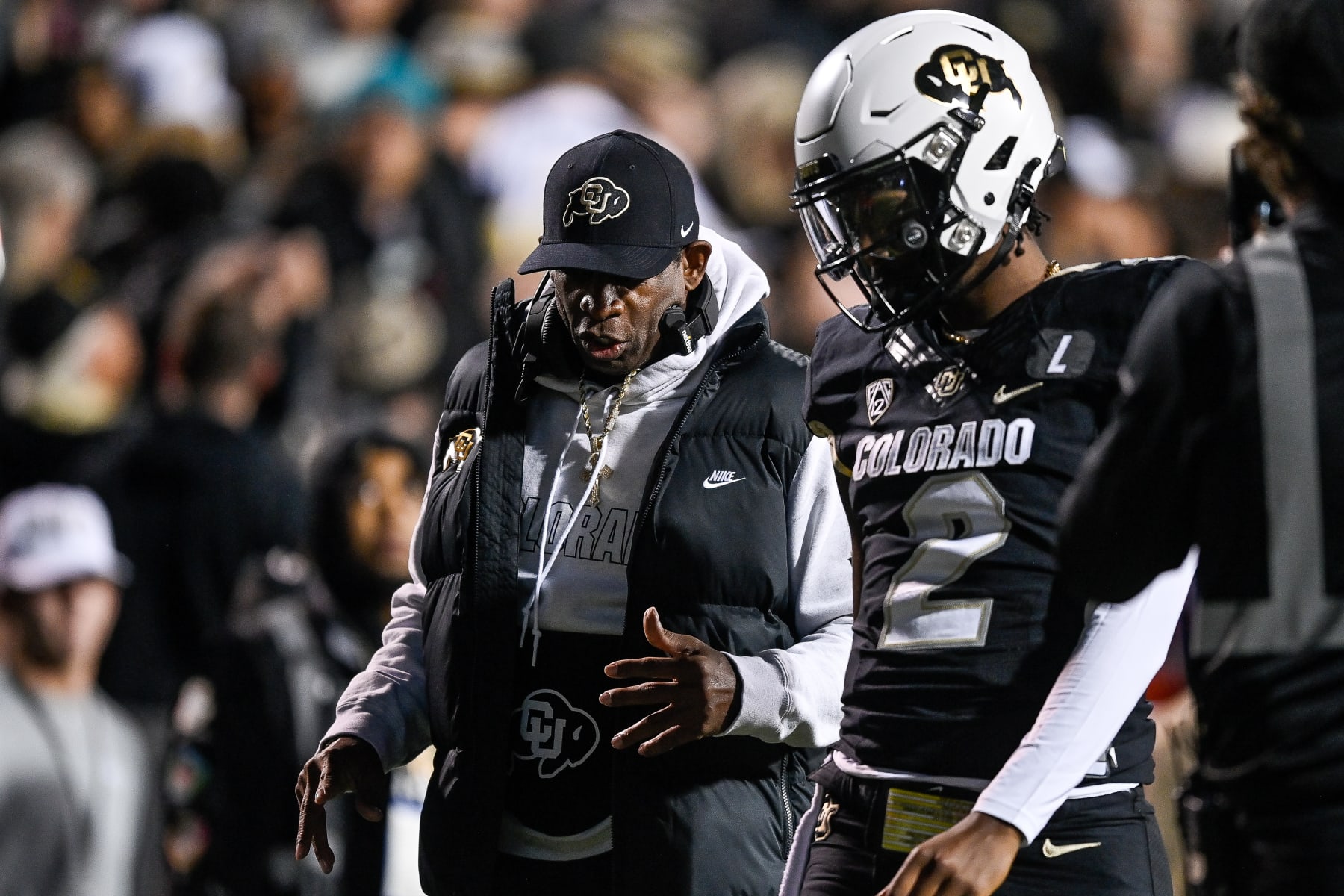 BOULDER, CO - NOVEMBER 4:  Head coach Deion Sanders of the Colorado Buffaloes has a word with quarterback Shedeur Sanders #2 before his first offensive drive in the first half of a game against the Oregon State Beavers at Folsom Field on November 4, 2023 in Boulder, Colorado. (Photo by Dustin Bradford/Getty Images)