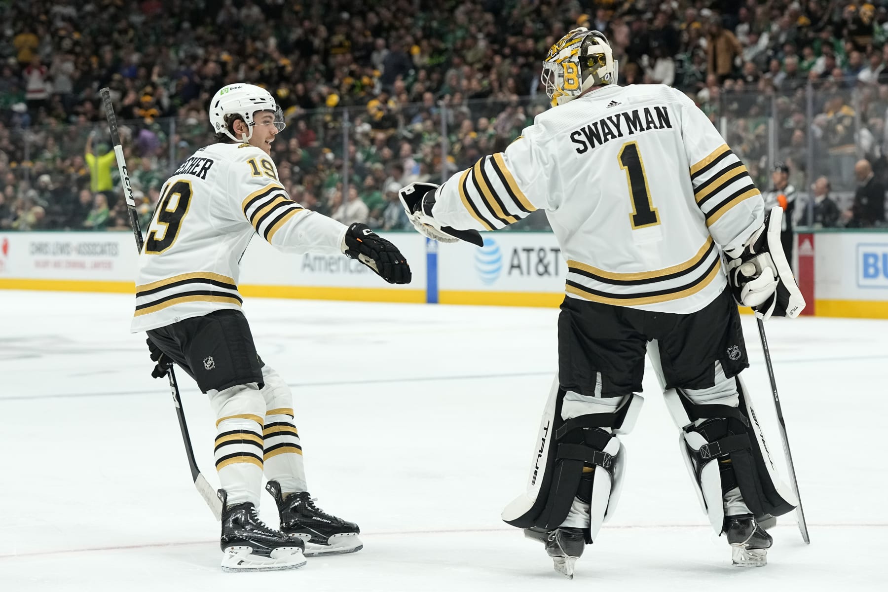 DALLAS, TEXAS - NOVEMBER 06: Johnny Beecher #19 of the Boston Bruins is congratulated by Jeremy Swayman #1 after scoring his first career NHL goal during the first period against the Dallas Stars at American Airlines Center on November 06, 2023 in Dallas, Texas. (Photo by Sam Hodde/Getty Images)
