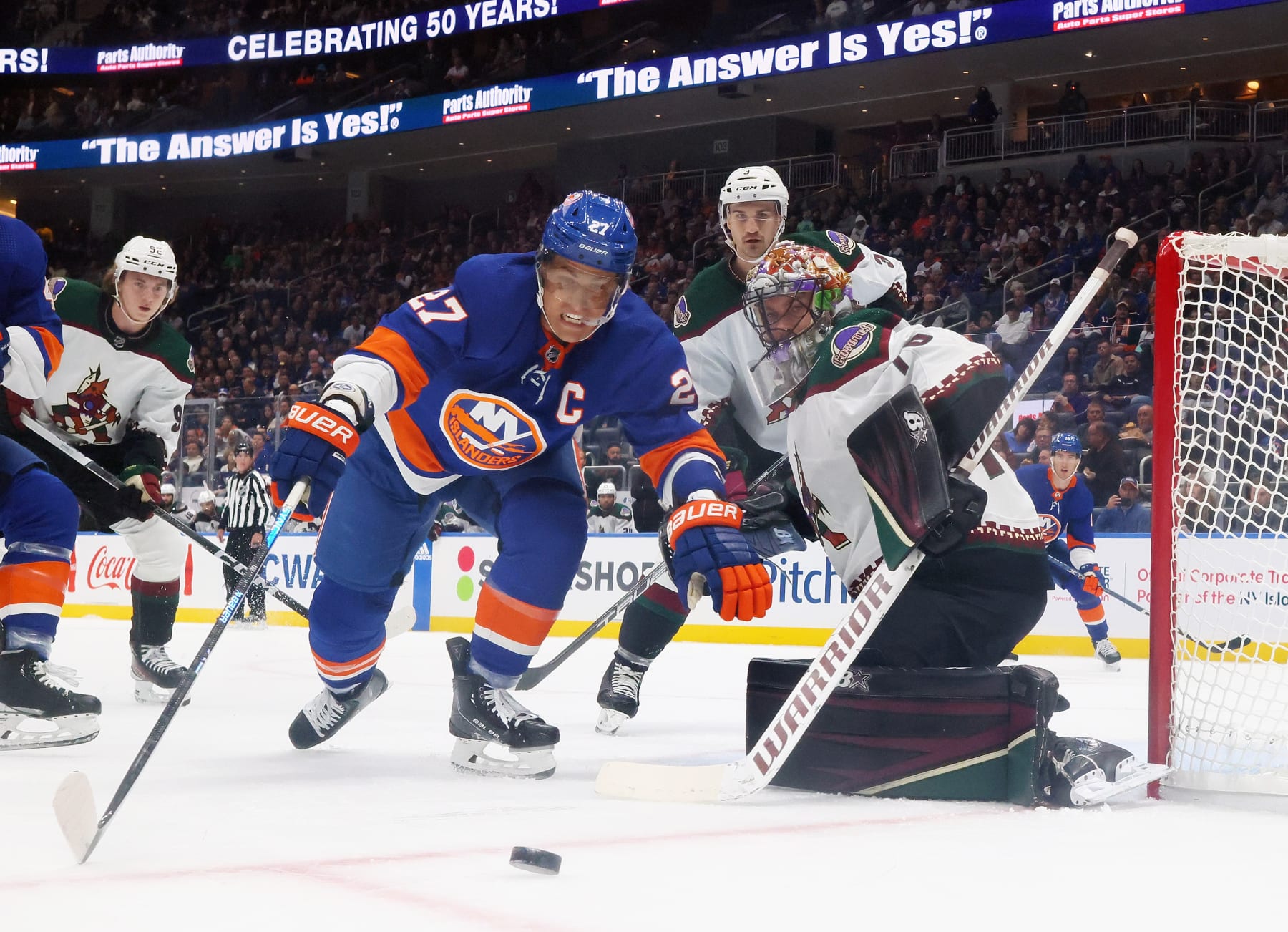 ELMONT, NEW YORK - OCTOBER 17: Anders Lee #27 of the New York Islanders attempts to control the puck in front of Karel Vejmelka #70 of the Arizona Coyotes at UBS Arena on October 17, 2023 in Elmont, New York. The Islanders shutout the Coyotes 1-0. (Photo by Bruce Bennett/Getty Images)