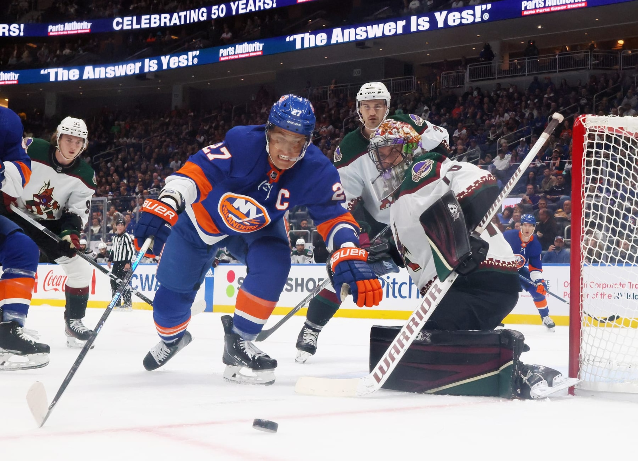 ELMONT, NEW YORK - OCTOBER 17: Anders Lee #27 of the New York Islanders attempts to control the puck in front of Karel Vejmelka #70 of the Arizona Coyotes at UBS Arena on October 17, 2023 in Elmont, New York. The Islanders shutout the Coyotes 1-0. (Photo by Bruce Bennett/Getty Images)