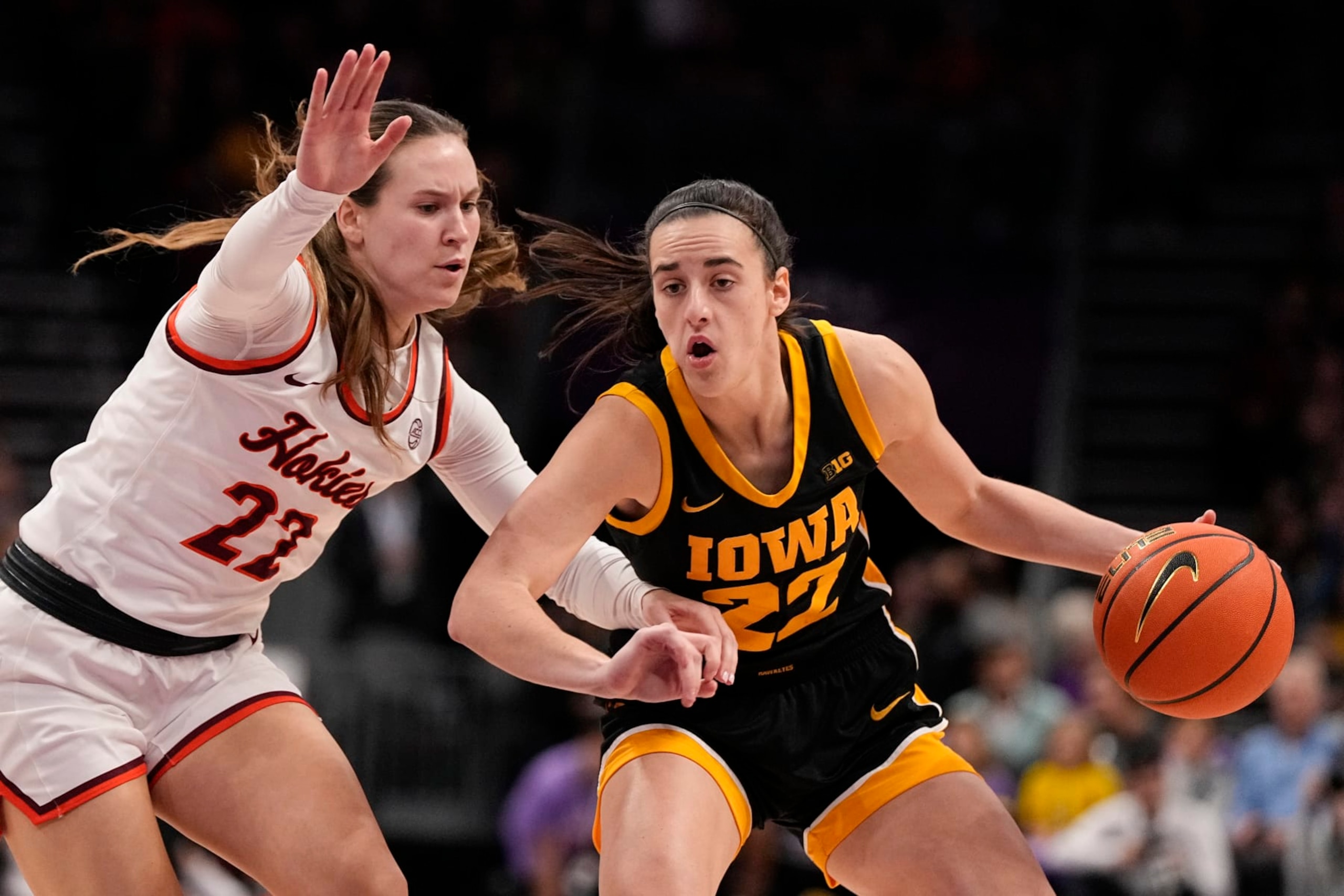 Iowa guard Caitlin Clark, right, drives to the basket past Virginia Tech guard Cayla King, left, during the first half of an NCAA women's college basketball game Thursday, Nov. 9, 2023, in Charlotte, N.C. (AP Photo/Chris Carlson)