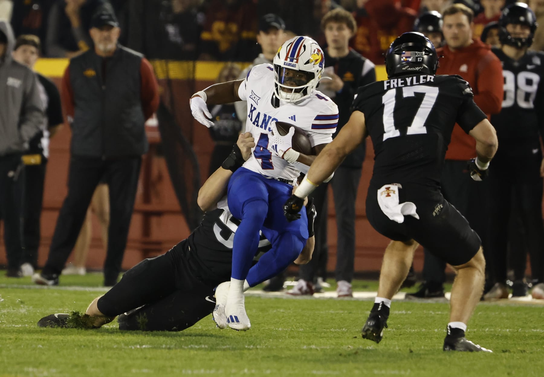 AMES, IA - NOVEMBER 4: Running back Devin Neal #4 of the Kansas Jayhawks is tackled by defensive end Joey Petersen #52 of the Iowa State Cyclones as defensive back Beau Freyler #17 of the Iowa State Cyclones defends in the first half of play at Jack Trice Stadium on November 4, 2023 in Ames, Iowa. The Kansas Jayhawks won 28-21 over the Iowa State Cyclones. (Photo by David K Purdy/Getty Images)