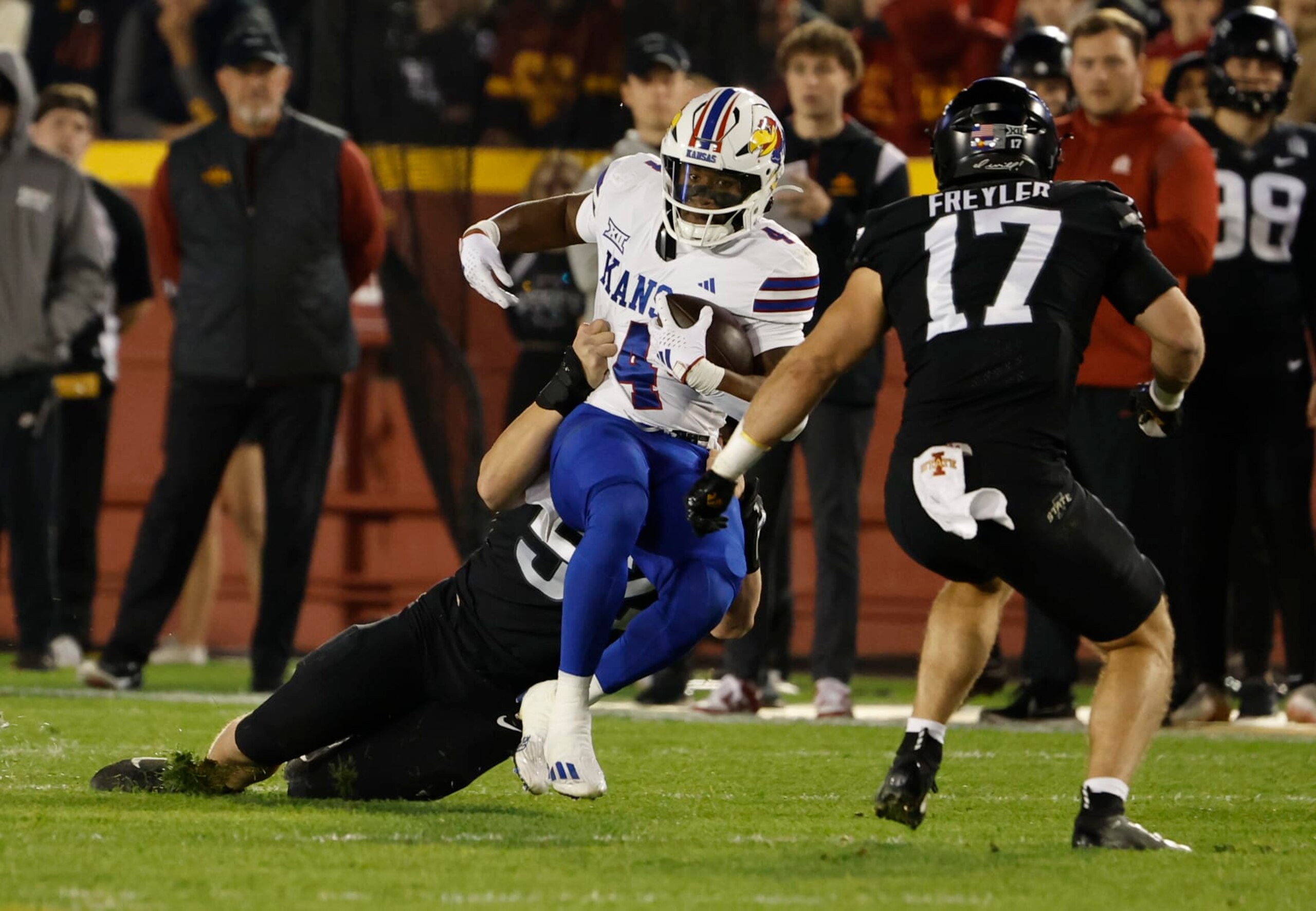 AMES, IA - NOVEMBER 4: Running back Devin Neal #4 of the Kansas Jayhawks is tackled by defensive end Joey Petersen #52 of the Iowa State Cyclones as defensive back Beau Freyler #17 of the Iowa State Cyclones defends in the first half of play at Jack Trice Stadium on November 4, 2023 in Ames, Iowa. The Kansas Jayhawks won 28-21 over the Iowa State Cyclones. (Photo by David K Purdy/Getty Images) AMES, IA - NOVEMBER 4: Running back Devin Neal #4 of the Kansas Jayhawks is tackled by defensive end Joey Petersen #52 of the Iowa State Cyclones as defensive back Beau Freyler #17 of the Iowa State Cyclones defends in the first half of play at Jack Trice Stadium on November 4, 2023 in Ames, Iowa. The Kansas Jayhawks won 28-21 over the Iowa State Cyclones. (Photo by David K Purdy/Getty Images)