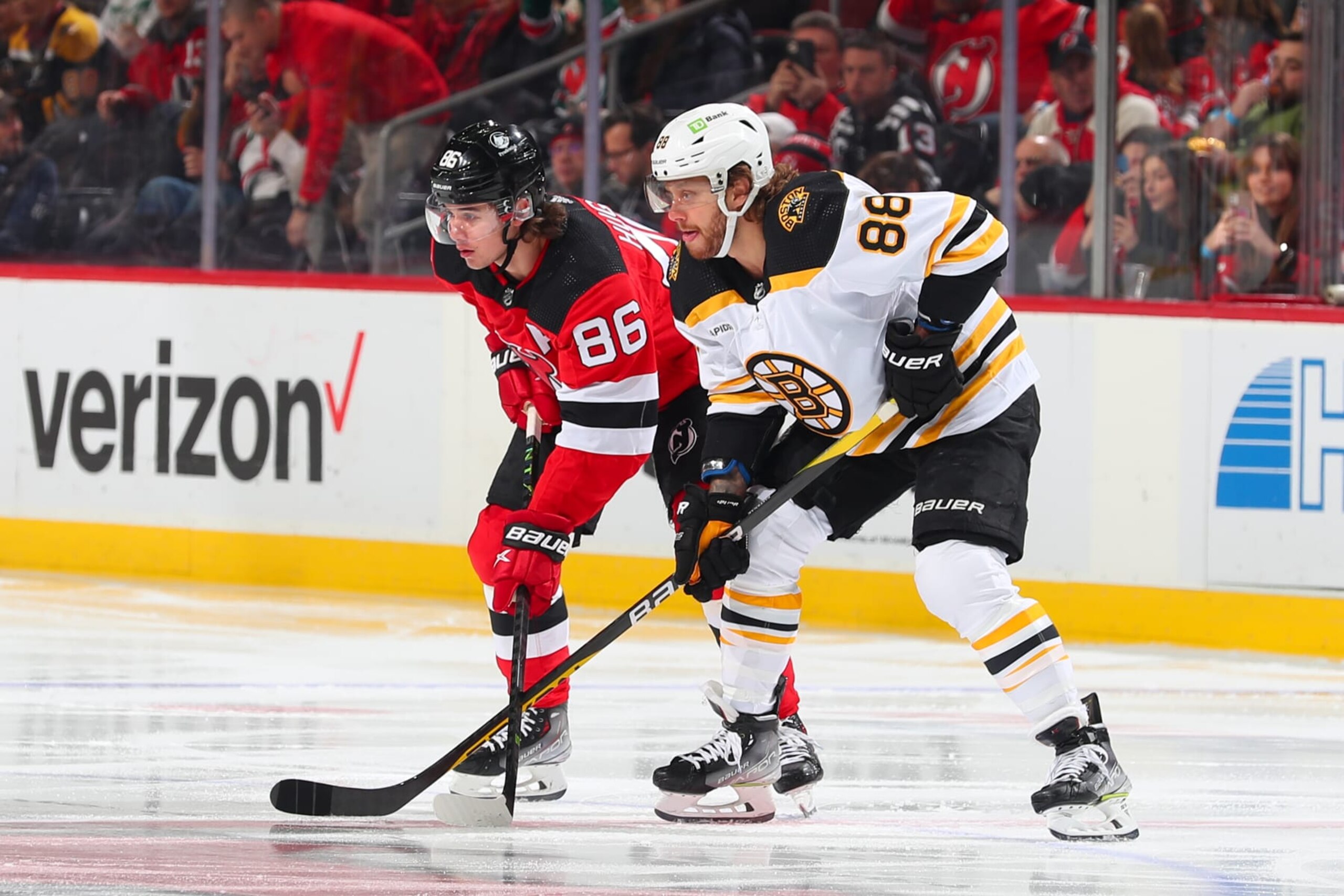 Boston Bruins winger David PastrÅák (right) and New Jersey Devils center Jack Hughes. 