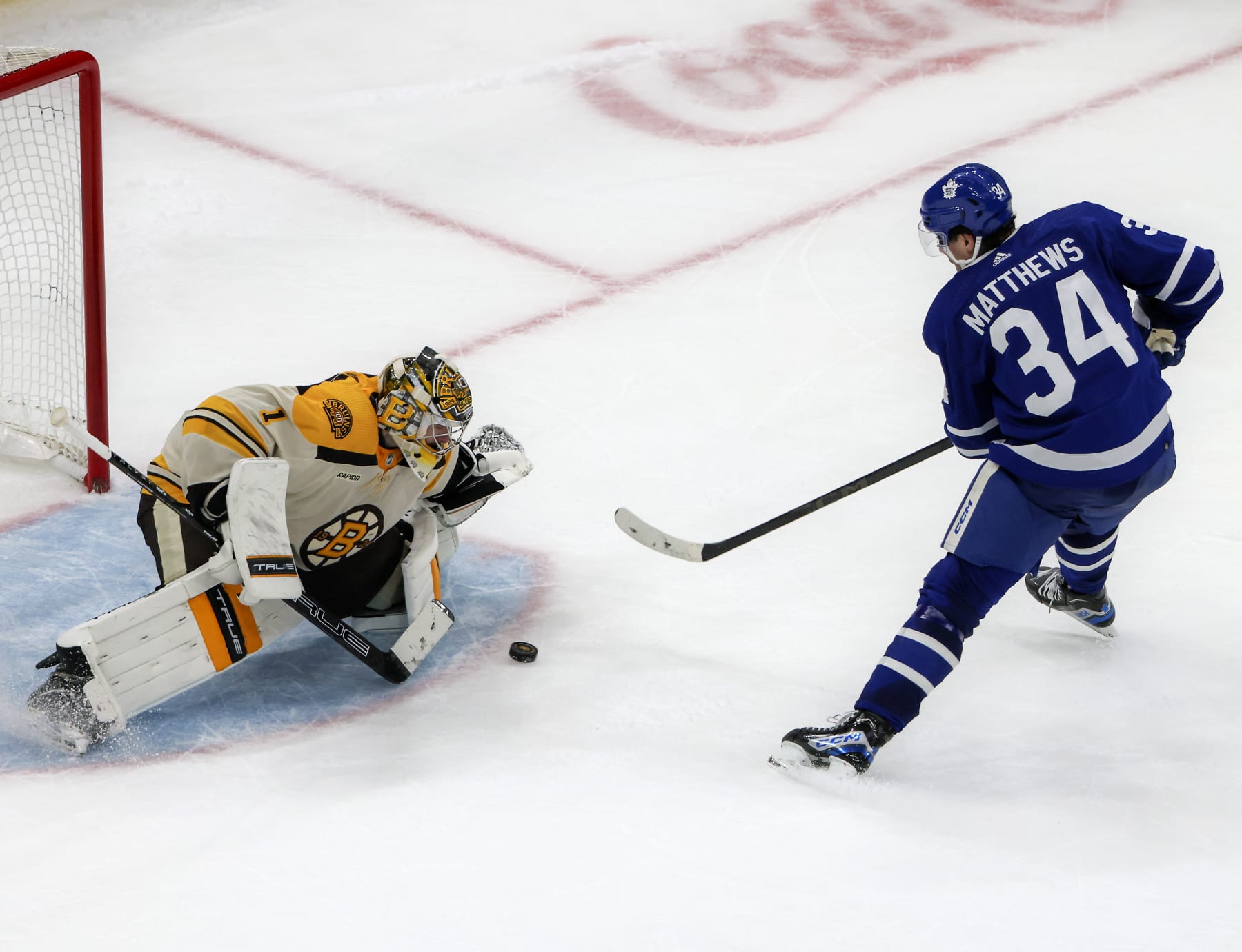 Boston Bruins goaltender Jeremy Swayman (left) stops Toronto Maple Leafs center Auston Matthews. 