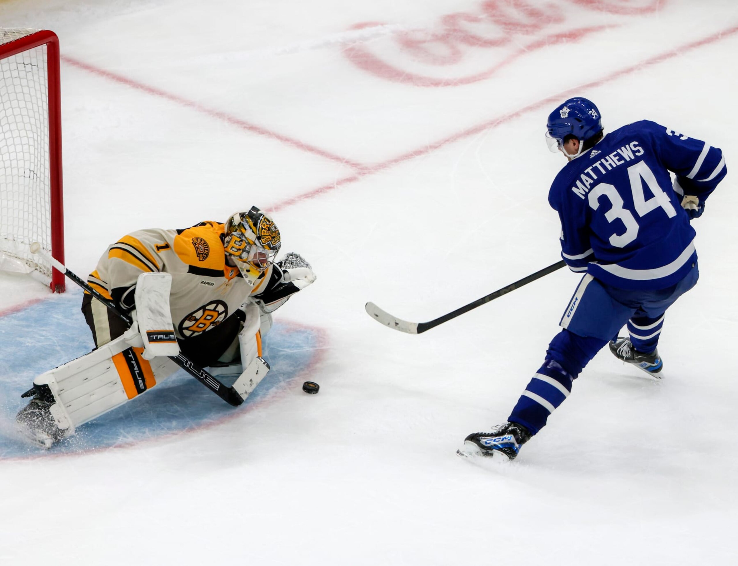 Boston Bruins goaltender Jeremy Swayman (left) stops Toronto Maple Leafs center Auston Matthews. 
