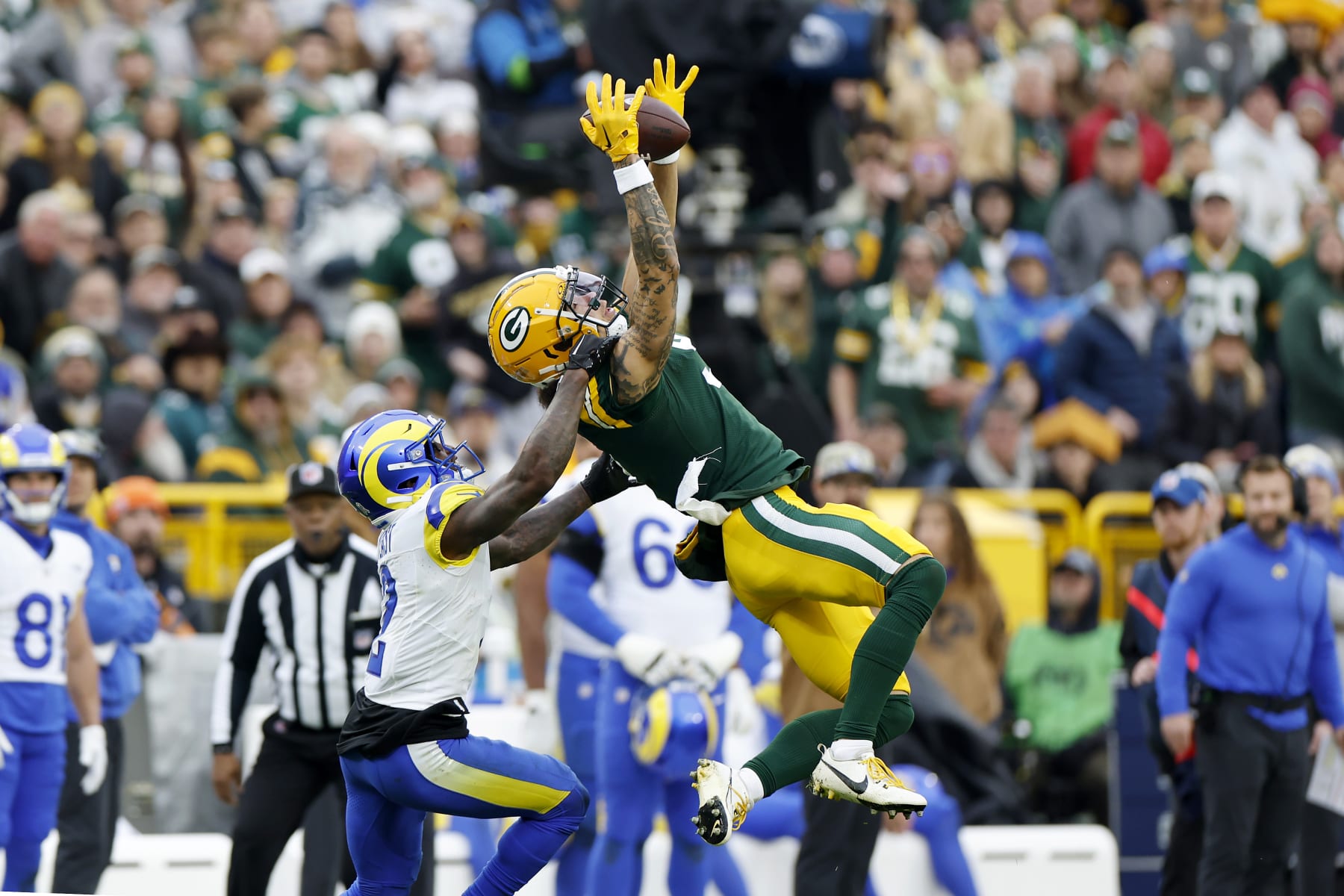 GREEN BAY, WISCONSIN - NOVEMBER 05: Christian Watson #9 of the Green Bay Packers catches a pass against Russ Yeast #2 of the Los Angeles Rams in the fourth quarter of a game at Lambeau Field on November 05, 2023 in Green Bay, Wisconsin. (Photo by John Fisher/Getty Images)