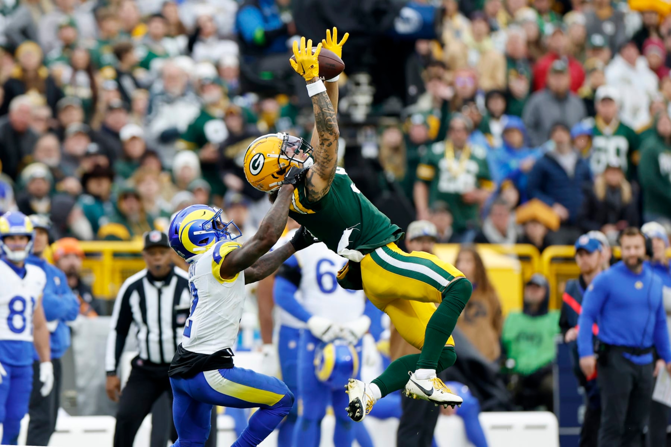 GREEN BAY, WISCONSIN - NOVEMBER 05: Christian Watson #9 of the Green Bay Packers catches a pass against Russ Yeast #2 of the Los Angeles Rams in the fourth quarter of a game at Lambeau Field on November 05, 2023 in Green Bay, Wisconsin. (Photo by John Fisher/Getty Images)