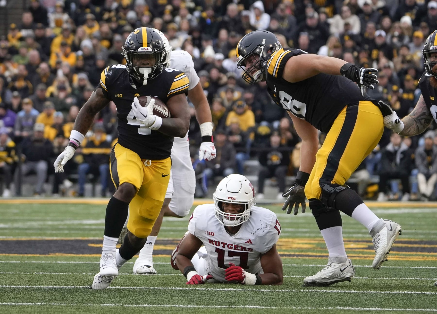 Iowa running back LeShon Williams, left, runs the ball against Rutgers during the first half of an NCAA college football game, Saturday, Nov. 11, 2023, in Iowa City, Iowa. (AP Photo/Bryon Houlgrave)