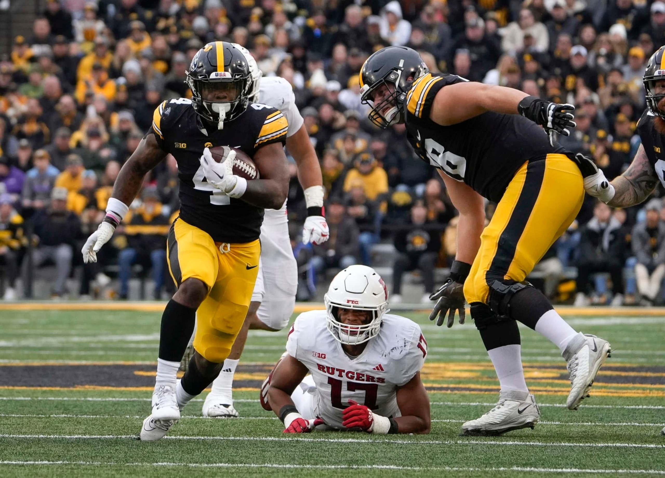 Iowa running back LeShon Williams, left, runs the ball against Rutgers during the first half of an NCAA college football game, Saturday, Nov. 11, 2023, in Iowa City, Iowa. (AP Photo/Bryon Houlgrave)