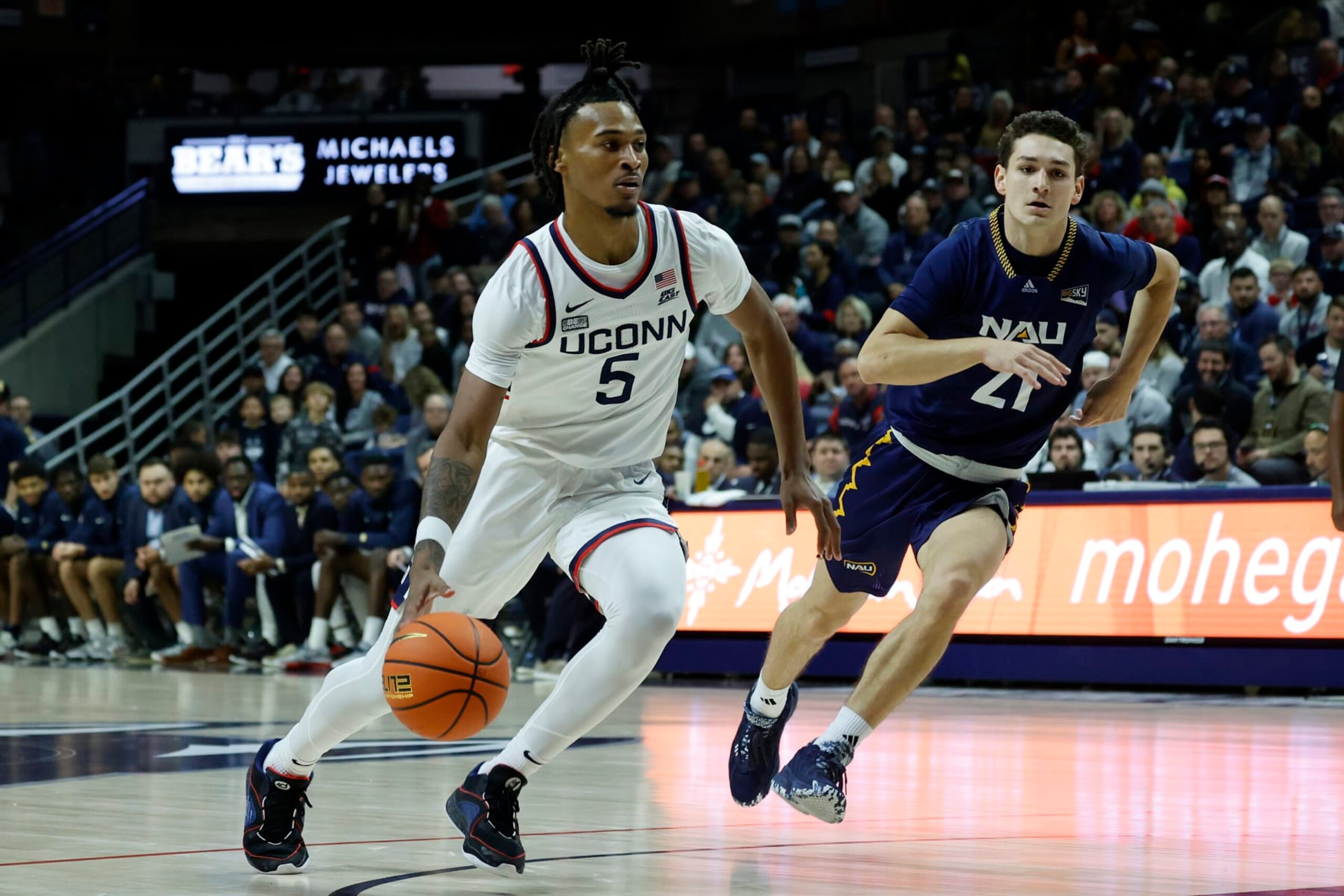 UConn guard Stephon Castle (5) drives past Northern Arizona guard Liam Lloyd during the first half of an NCAA college basketball game, Monday, Nov. 6, 2023, in Storrs, Conn. (AP Photo/Mary Schwalm)