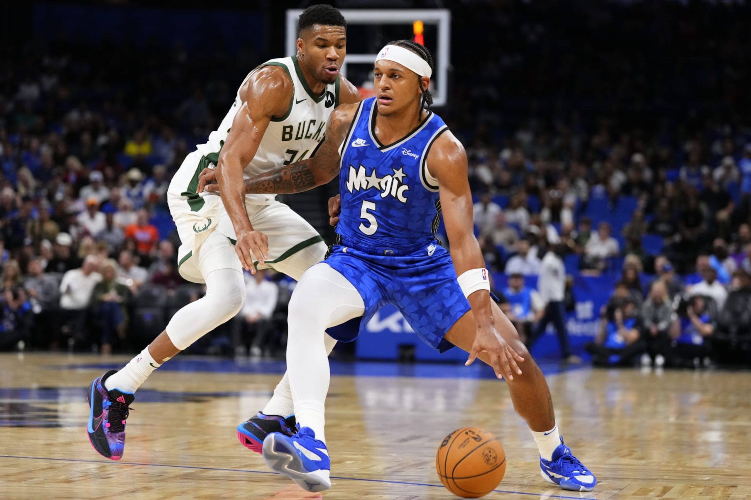 ORLANDO, FLORIDA - NOVEMBER 11: Paolo Banchero #5 of the Orlando Magic dribbles the ball past Giannis Antetokounmpo #34 of the Milwaukee Bucks during the first quarter at Amway Center on November 11, 2023 in Orlando, Florida. NOTE TO USER : User expressly acknowledges and agrees that, by downloading and or using this photograph, User is consenting to the terms and conditions of the Getty Images License Agreement. (Photo by Rich Storry/Getty Images)