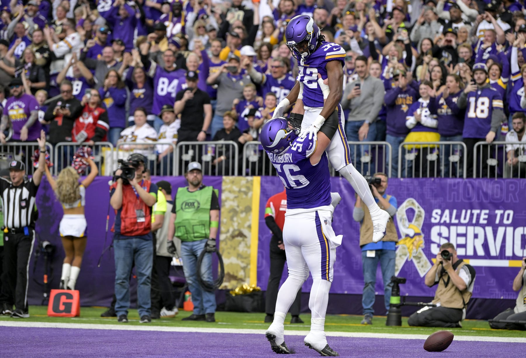MINNEAPOLIS, MN - NOVEMBER 12: Minnesota Vikings running back Ty Chandler (32) celebrates his 2-yard touchdown run with Minnesota Vikings offensive lineman Garrett Bradbury (56) during the second quarter of an NFL game between the Minnesota Vikings and New Orleans Saints on November 12, 2023, at U.S. Bank Stadium in Minneapolis, MN. (Photo by Nick Wosika/Icon Sportswire via Getty Images)