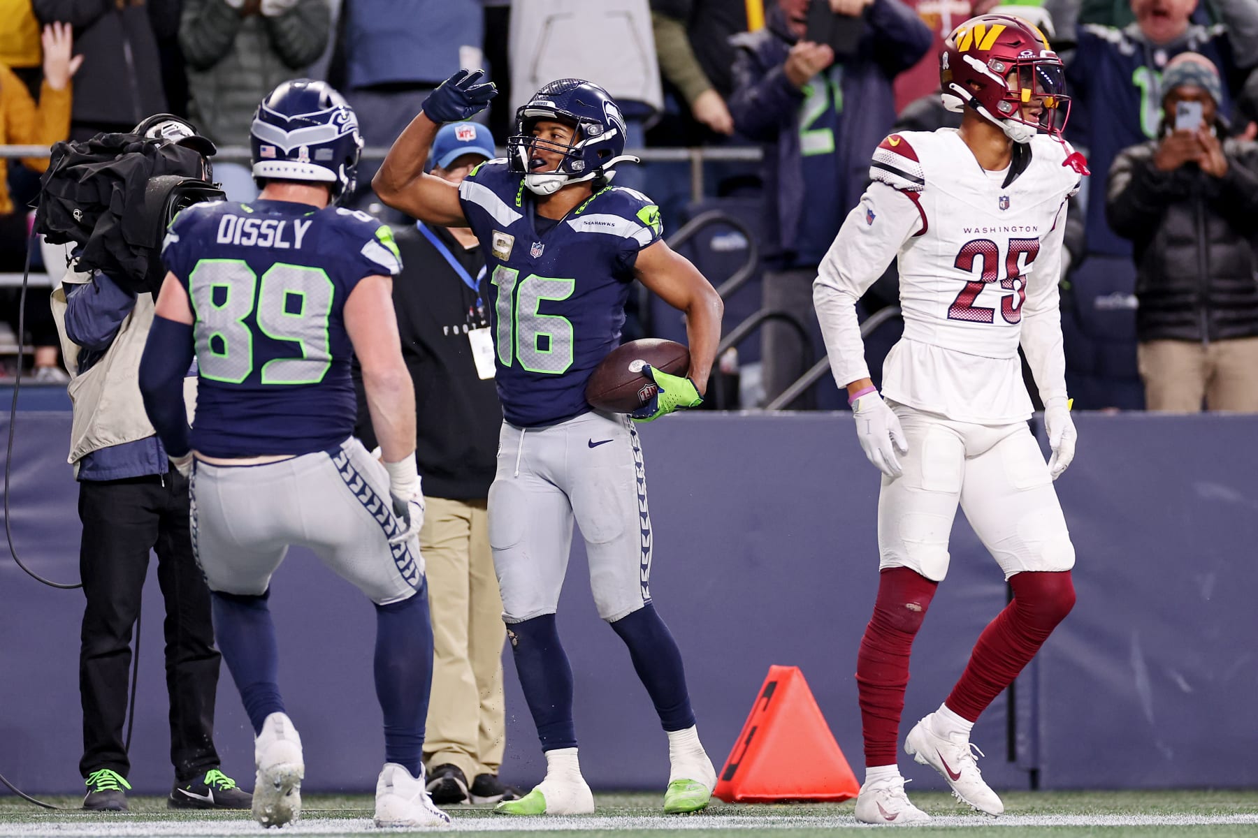 SEATTLE, WASHINGTON - NOVEMBER 12: Will Dissly #89 of the Seattle Seahawks celebrates with Tyler Lockett #16 of the Seattle Seahawks while Benjamin St-Juste #25 of the Washington Commanders looks on after Lockett's receiving touchdown during the fourth quarter at Lumen Field on November 12, 2023 in Seattle, Washington. (Photo by Steph Chambers/Getty Images)