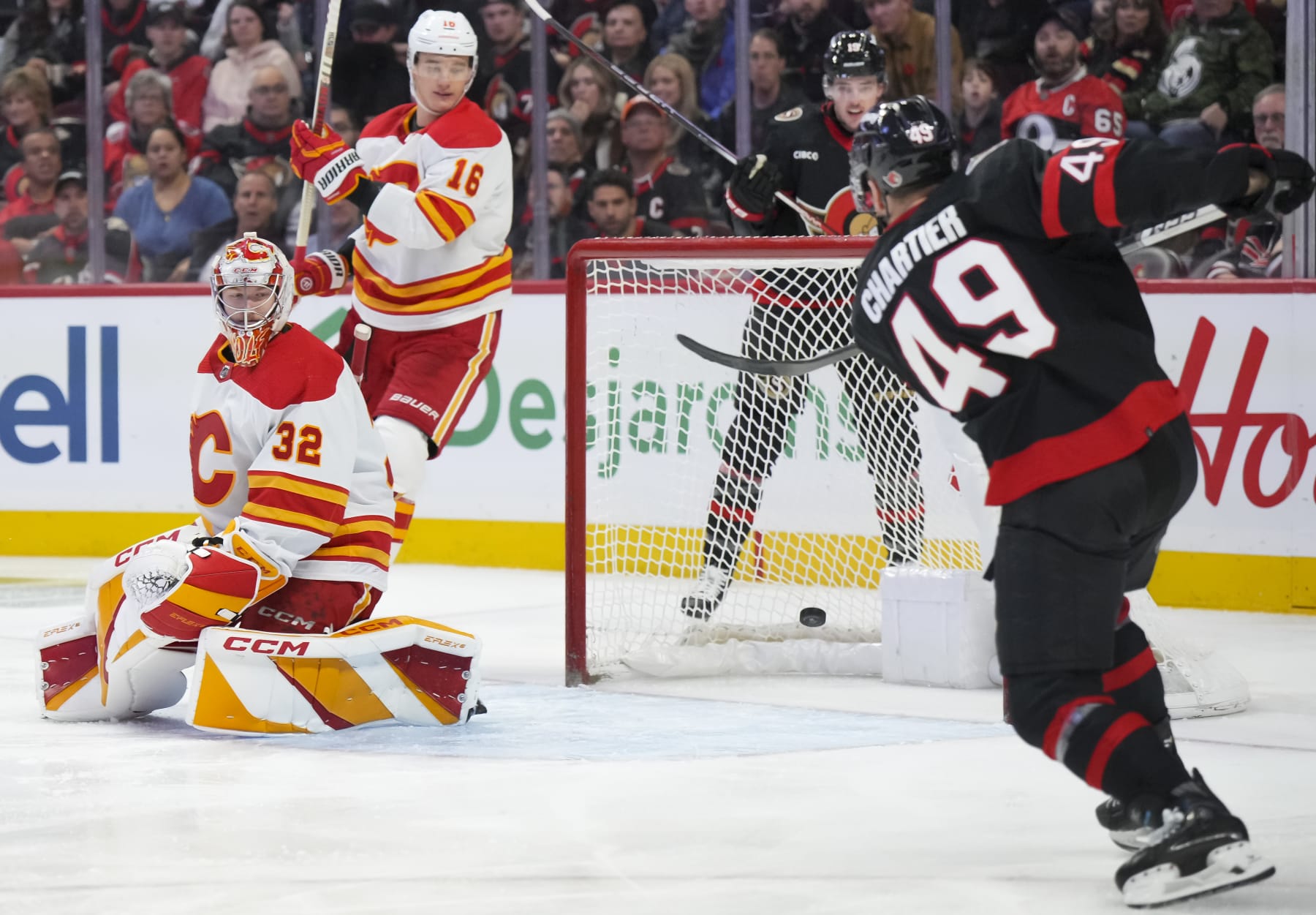 OTTAWA, CANADA - NOVEMBER 11: Rourke Chartier #49 of the Ottawa Senators scores a third period goal against Dustin Wolf #32 of the Calgary Flames at Canadian Tire Centre on November 11, 2023 in Ottawa, Ontario, Canada.  (Photo by André Ringuette/NHLI via Getty Images)