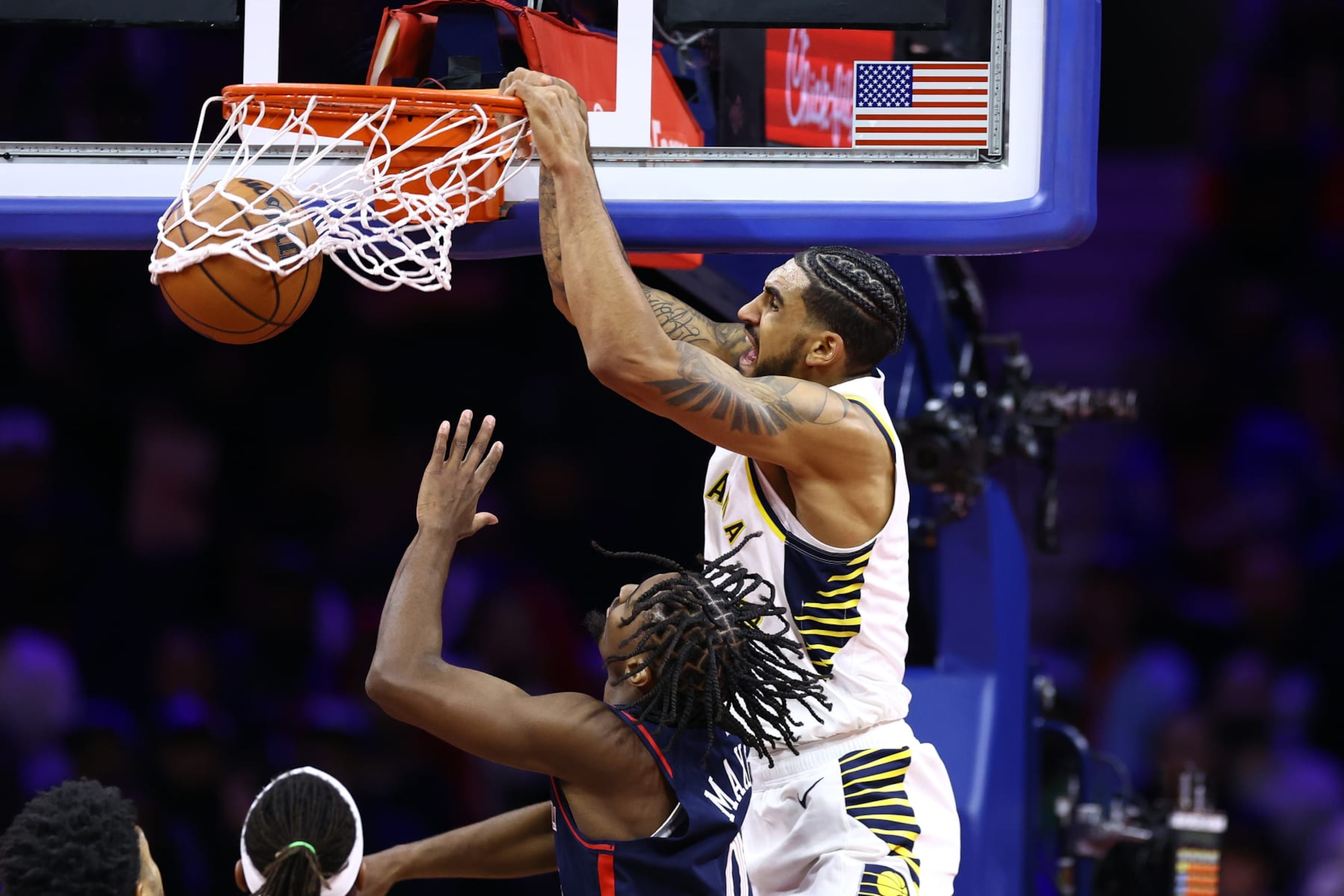 PHILADELPHIA, PENNSYLVANIA - NOVEMBER 14: Obi Toppin #1 of the Indiana Pacers dunks past Tyrese Maxey #0 of the Philadelphia 76ers during the fourth quarter  at the Wells Fargo Center on November 14, 2023 in Philadelphia, Pennsylvania. NOTE TO USER: User expressly acknowledges and agrees that, by downloading and or using this photograph, User is consenting to the terms and conditions of the Getty Images License Agreement. (Photo by Tim Nwachukwu/Getty Images)