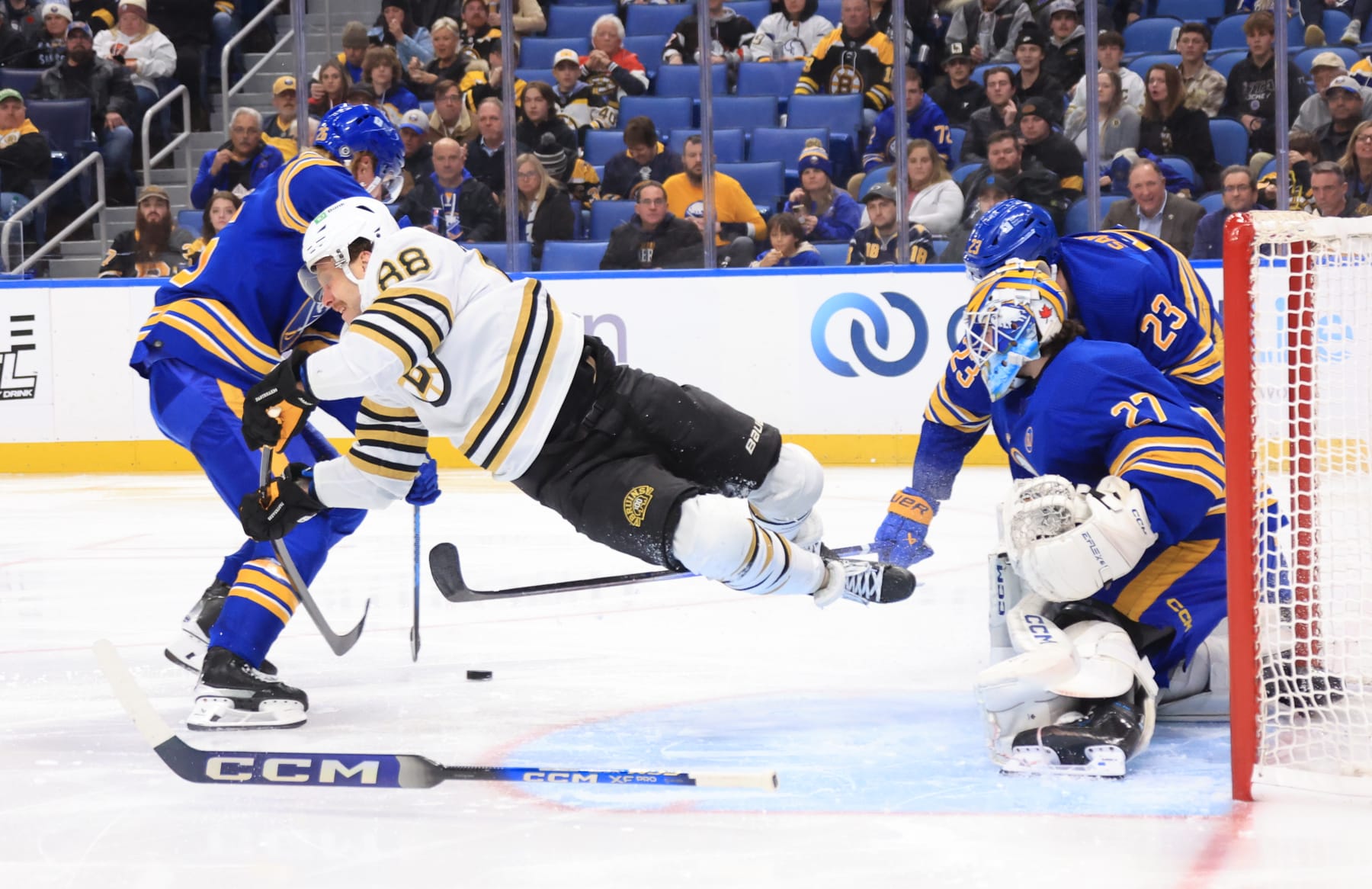 BUFFALO, NEW YORK - NOVEMBER 14: David Pastrnak #88 of the Boston Bruins is upset while battling against Rasmus Dahlin #26, Mattias Samuelsson #23 and Devon Levi #27 of the Buffalo Sabres during an NHL game on November 14, 2023 at KeyBank Center in Buffalo, New York. (Photo by Bill Wippert/NHLI via Getty Images)