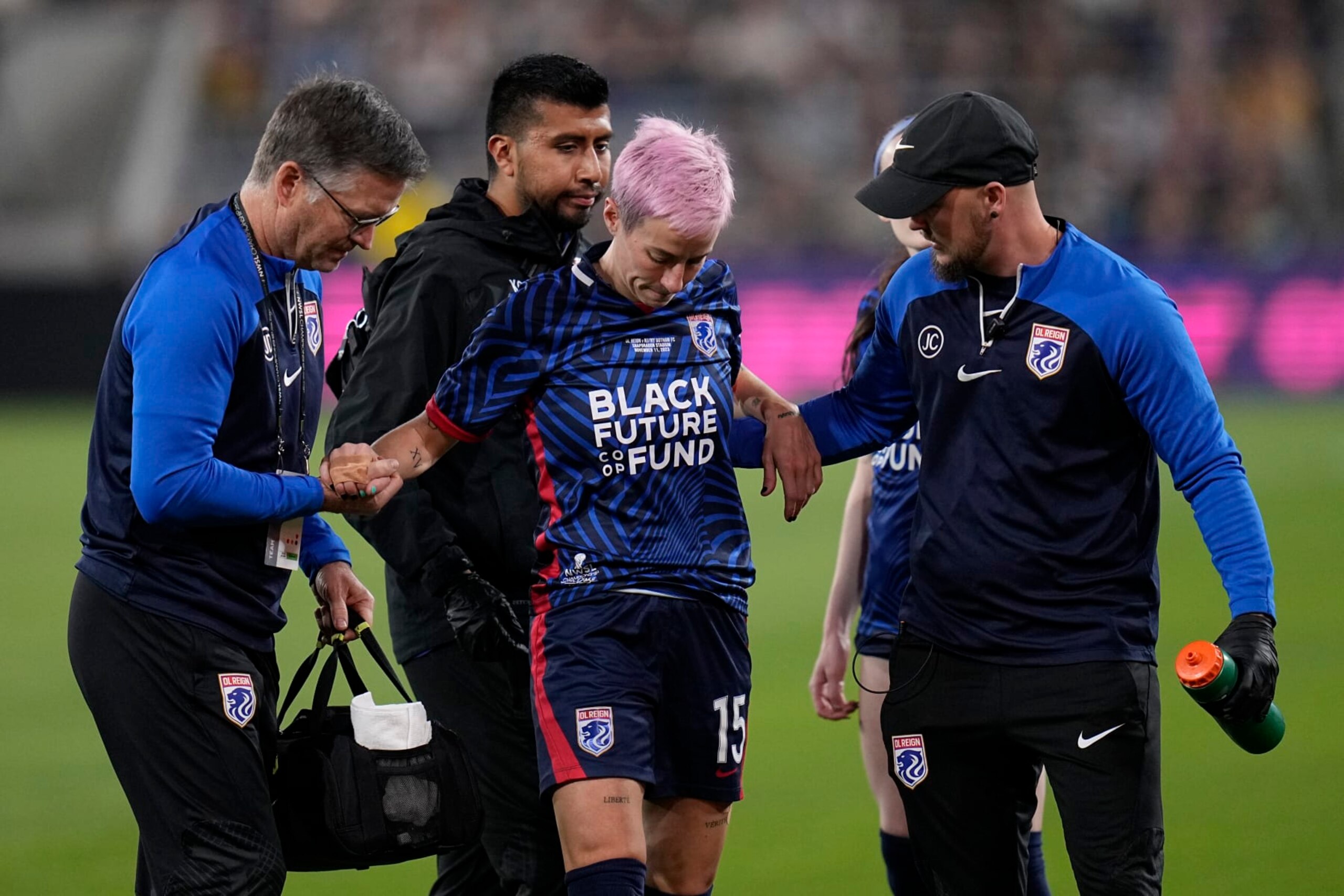 OL Reign forward Megan Rapinoe is helped up by team officials after an injury during the first half of the NWSL Championship soccer game against NJ/NY Gotham, Saturday, Nov. 11, 2023, in San Diego. (AP Photo/Gregory Bull) OL Reign forward Megan Rapinoe is helped up by team officials after an injury during the first half of the NWSL Championship soccer game against NJ/NY Gotham, Saturday, Nov. 11, 2023, in San Diego. (AP Photo/Gregory Bull)
