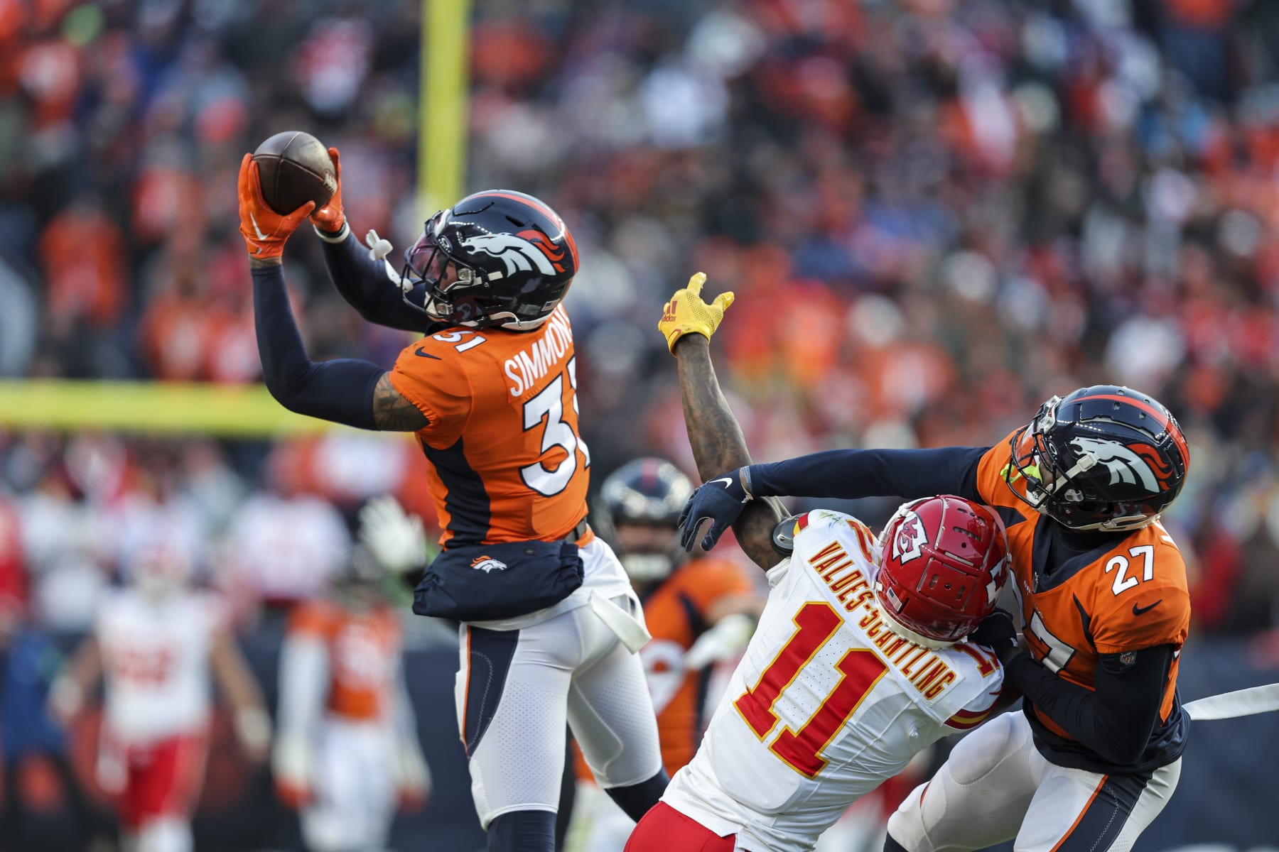 DENVER, COLORADO - OCTOBER 29: Justin Simmons #31 of the Denver Broncos intercepts a ball intended for Marquez Valdes-Scantling #11 of the Kansas City Chiefs during an NFL football game between the Denver Broncos and the Kansas City Chiefs at Empower Field At Mile High on October 29, 2023 in Denver, Colorado. (Photo by Michael Owens/Getty Images)