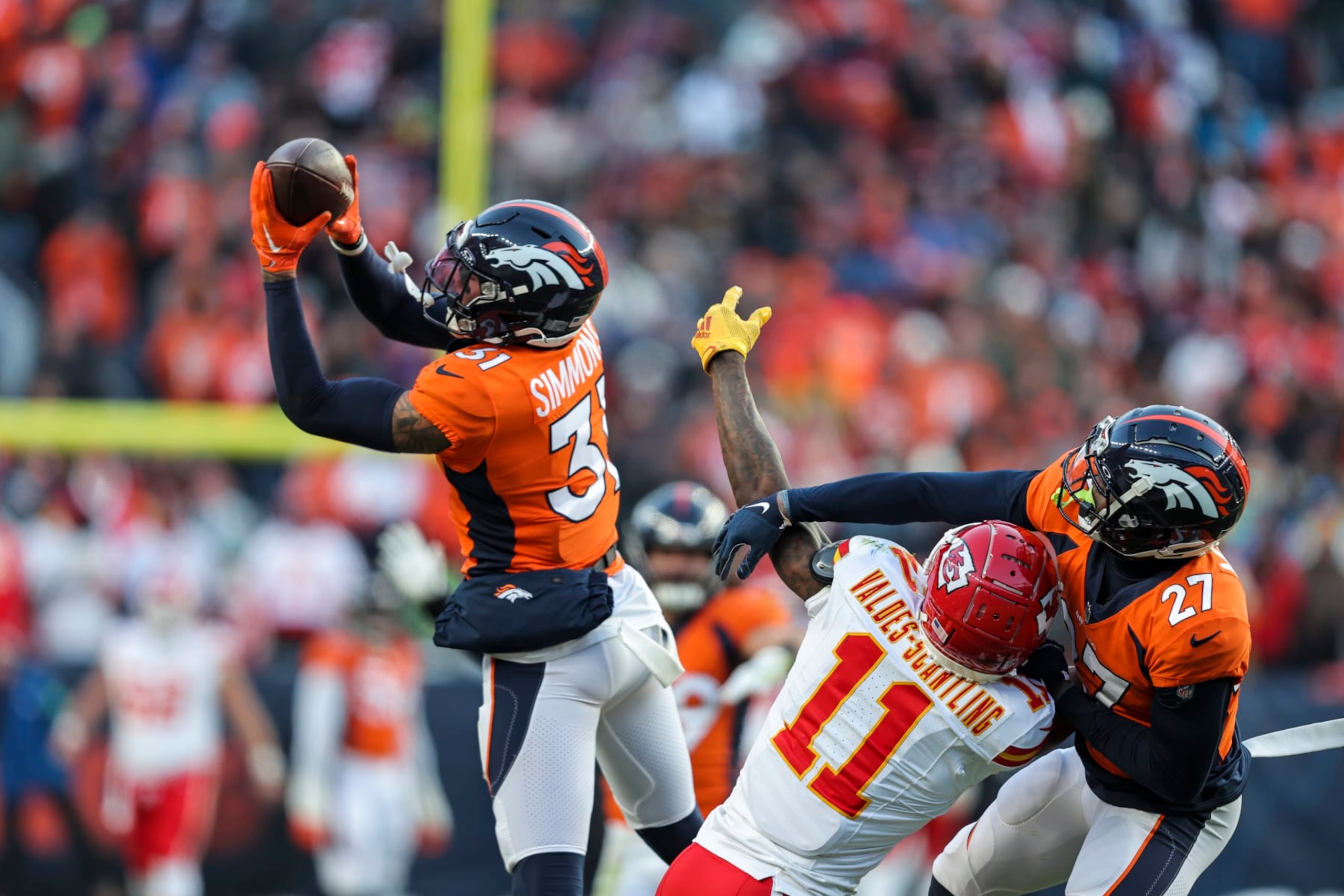 DENVER, COLORADO - OCTOBER 29: Justin Simmons #31 of the Denver Broncos intercepts a ball intended for Marquez Valdes-Scantling #11 of the Kansas City Chiefs during an NFL football game between the Denver Broncos and the Kansas City Chiefs at Empower Field At Mile High on October 29, 2023 in Denver, Colorado. (Photo by Michael Owens/Getty Images)