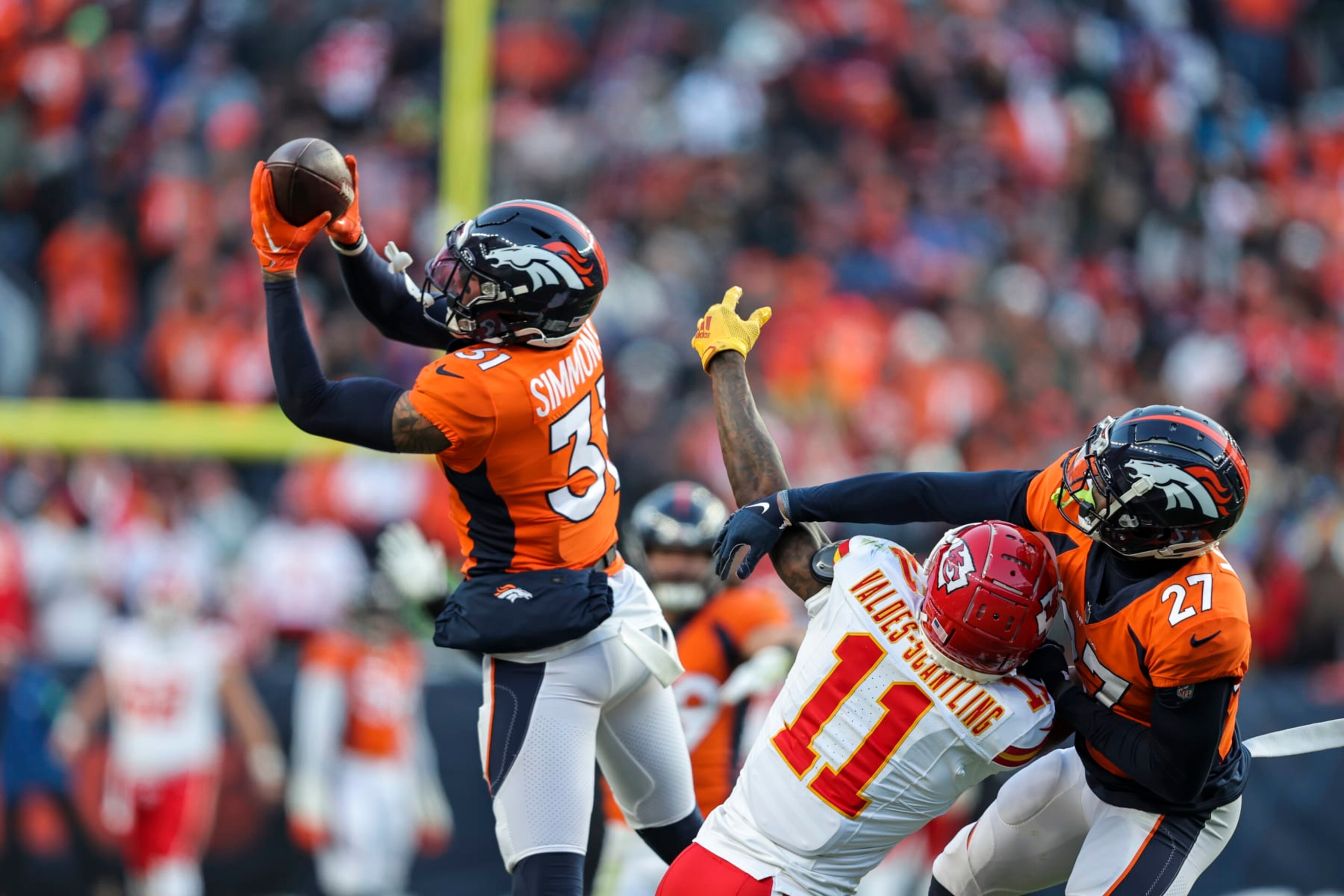 DENVER, COLORADO - OCTOBER 29: Justin Simmons #31 of the Denver Broncos intercepts a ball intended for Marquez Valdes-Scantling #11 of the Kansas City Chiefs during an NFL football game between the Denver Broncos and the Kansas City Chiefs at Empower Field At Mile High on October 29, 2023 in Denver, Colorado. (Photo by Michael Owens/Getty Images)