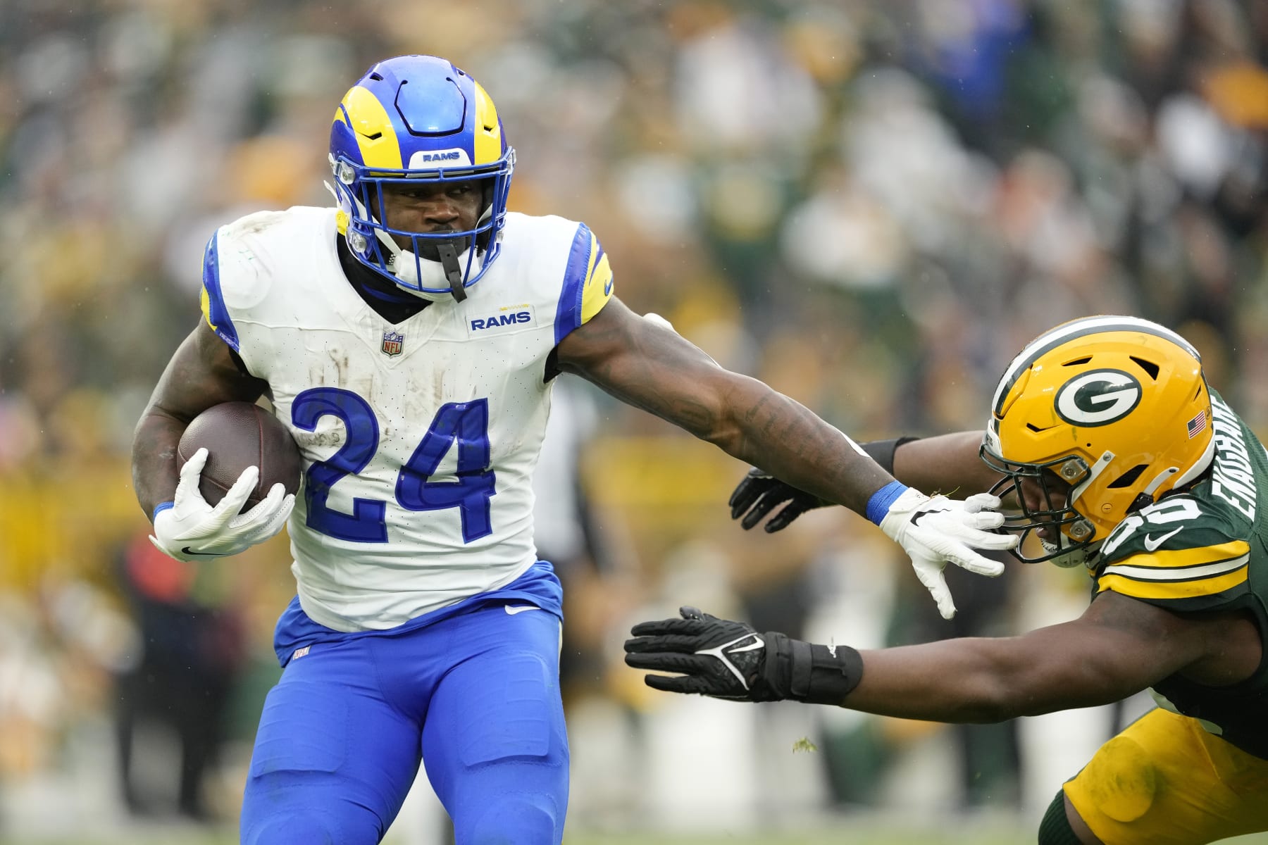 GREEN BAY, WISCONSIN - NOVEMBER 05: Royce Freeman #24 of the Los Angeles Rams avoids the tackle of Kingsley Enagbare #55 of the Green Bay Packers in the second half at Lambeau Field on November 05, 2023 in Green Bay, Wisconsin. (Photo by Patrick McDermott/Getty Images)