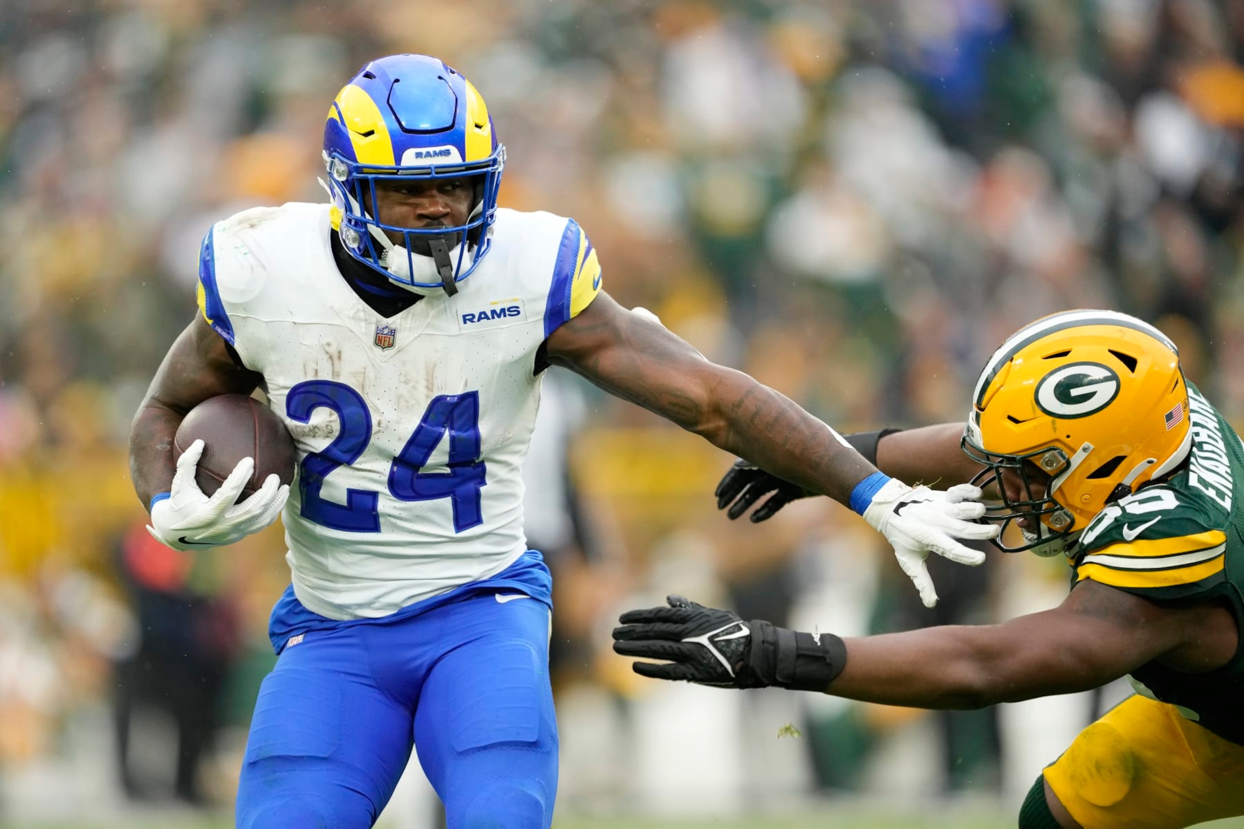 GREEN BAY, WISCONSIN - NOVEMBER 05: Royce Freeman #24 of the Los Angeles Rams avoids the tackle of Kingsley Enagbare #55 of the Green Bay Packers in the second half at Lambeau Field on November 05, 2023 in Green Bay, Wisconsin. (Photo by Patrick McDermott/Getty Images)