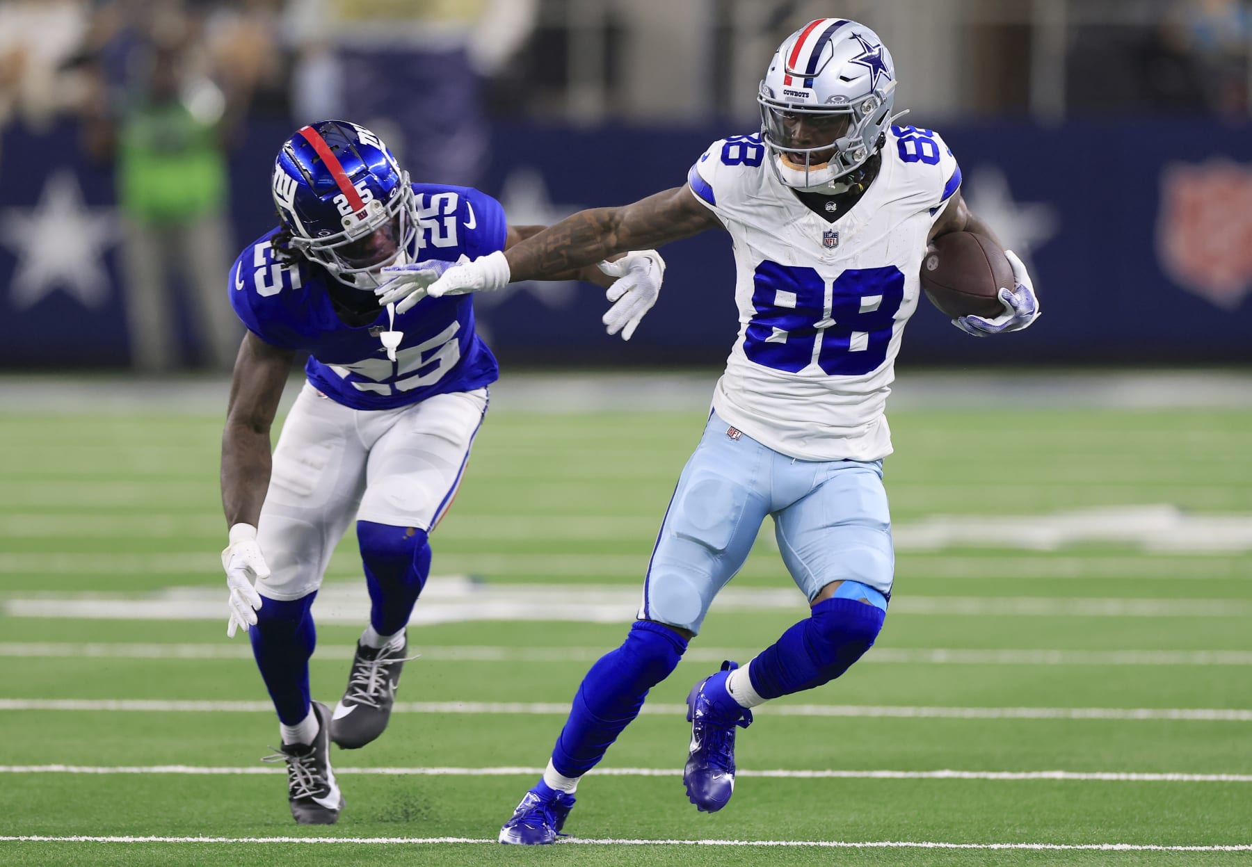 ARLINGTON, TEXAS - NOVEMBER 12: CeeDee Lamb #88 of the Dallas Cowboys runs with the ball against Deonte Banks #25 of the New York Giants during the second quarter at AT&T Stadium on November 12, 2023 in Arlington, Texas. (Photo by Ron Jenkins/Getty Images)