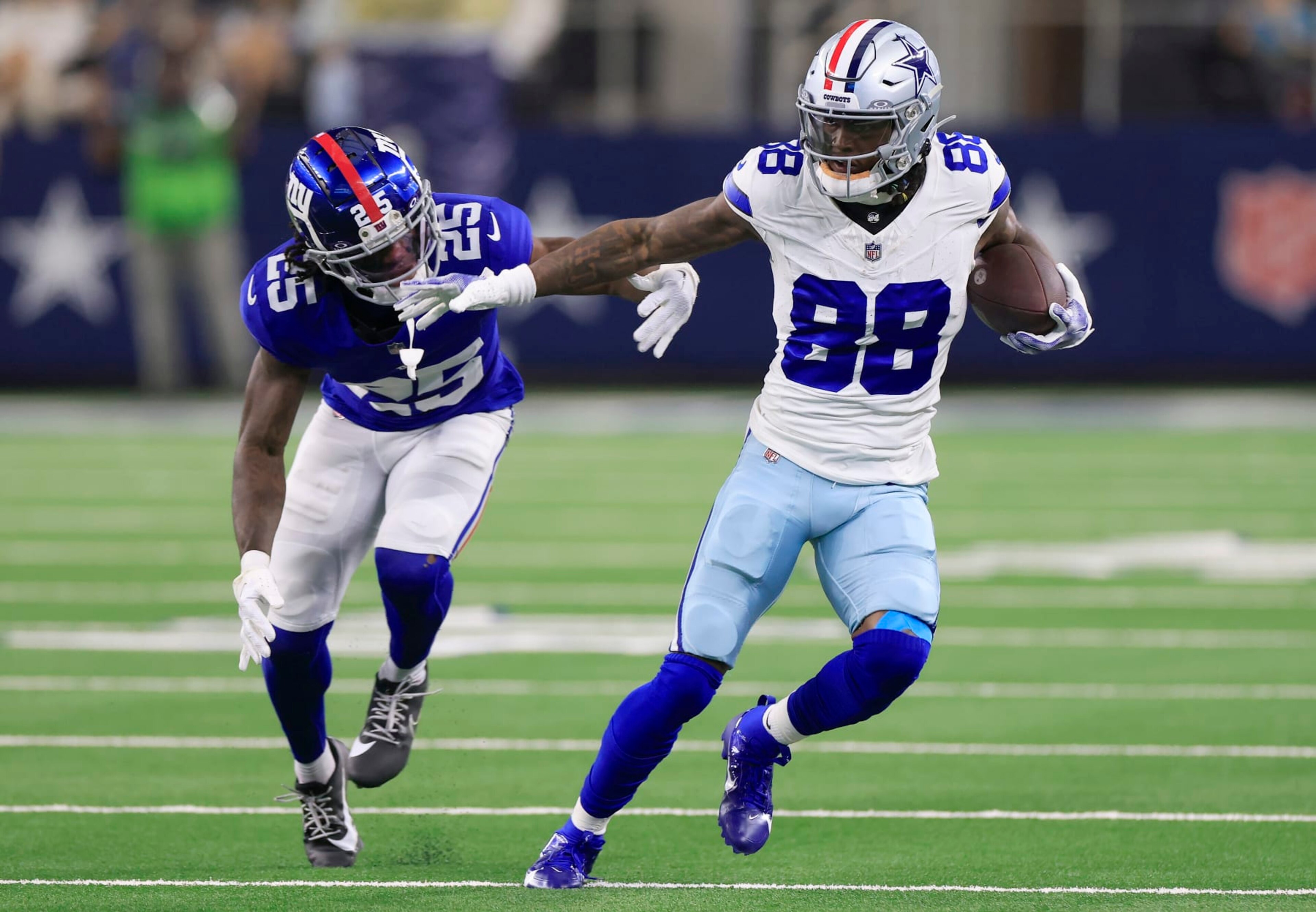 ARLINGTON, TEXAS - NOVEMBER 12: CeeDee Lamb #88 of the Dallas Cowboys runs with the ball against Deonte Banks #25 of the New York Giants during the second quarter at AT&T Stadium on November 12, 2023 in Arlington, Texas. (Photo by Ron Jenkins/Getty Images)