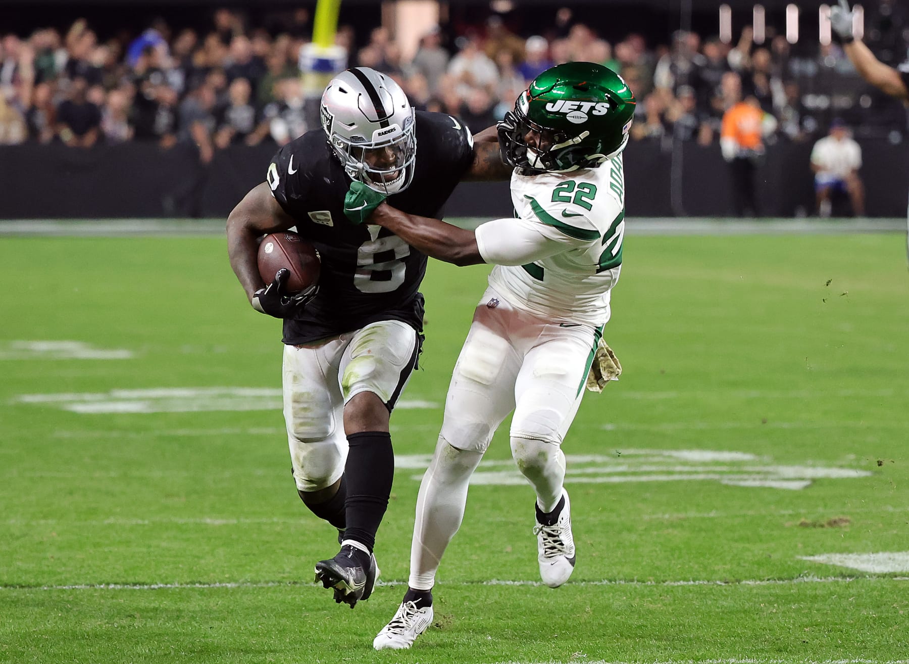 LAS VEGAS, NEVADA - NOVEMBER 12:  Running back Josh Jacobs #8 of the Las Vegas Raiders carries the ball as safety Tony Adams #22 of the New York Jets defends during the second half of the game at Allegiant Stadium on November 12, 2023 in Las Vegas, Nevada. (Photo by Ethan Miller/Getty Images)