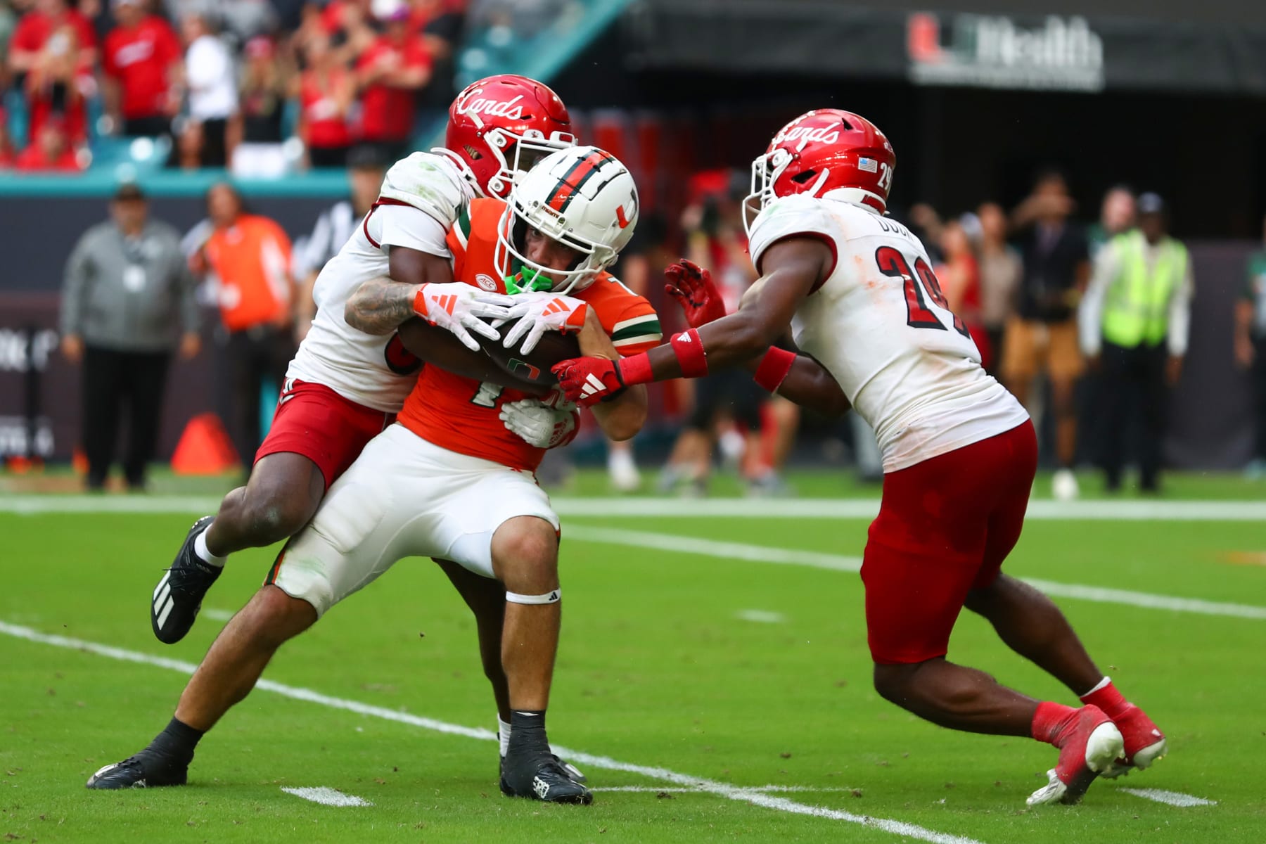 MIAMI GARDENS, FLORIDA - NOVEMBER 18: Xavier Restrepo #7 of the Miami Hurricanes carries the ball against the Louisville Cardinals during the fourth quarter of the game at Hard Rock Stadium on November 18, 2023 in Miami Gardens, Florida. (Photo by Megan Briggs/Getty Images)