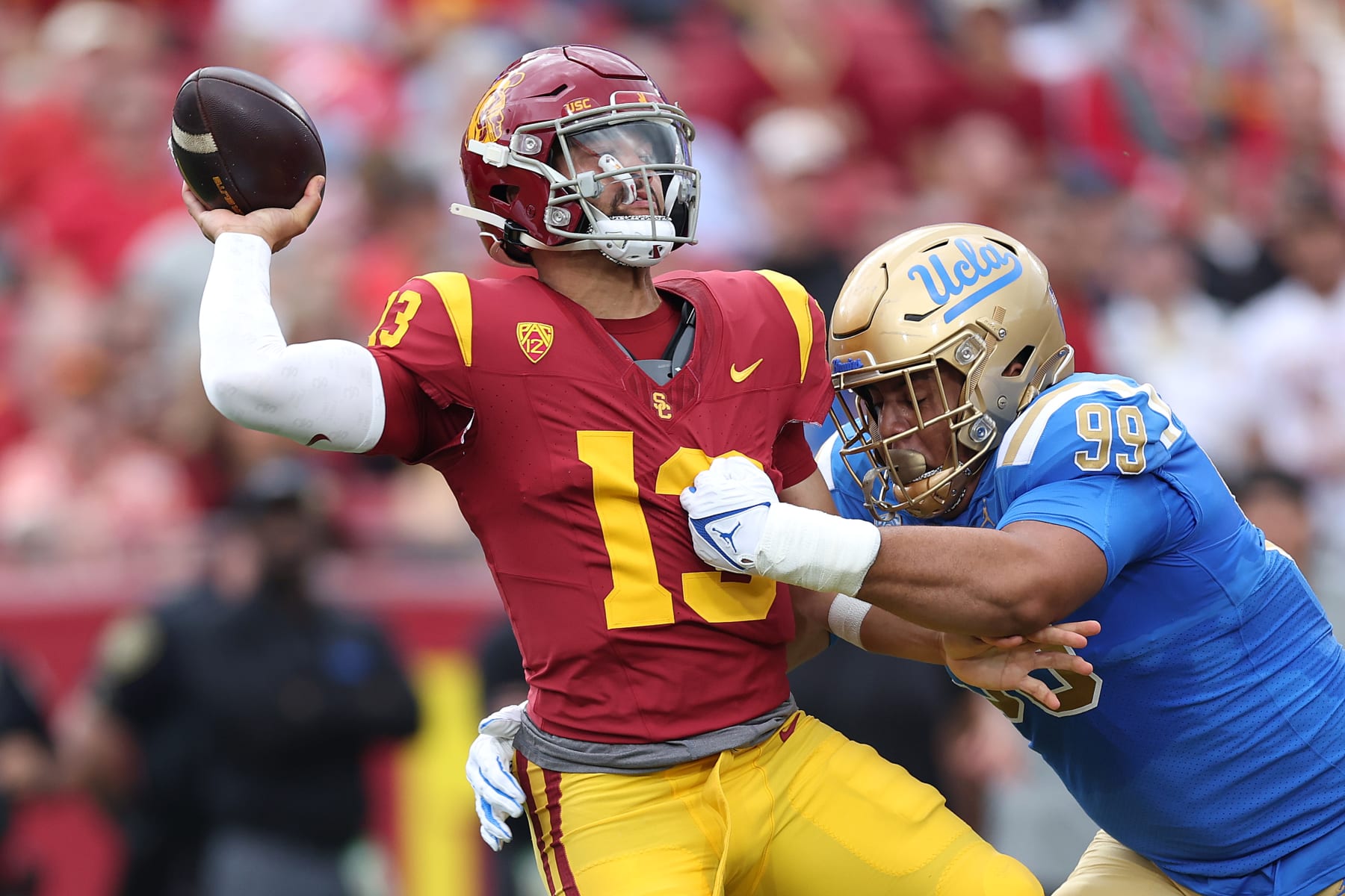 LOS ANGELES, CALIFORNIA - NOVEMBER 18: Keanu Williams #99 of the UCLA Bruins pressures Caleb Williams #13 of the USC Trojans during the first half of a game against the UCLA Bruins at United Airlines Field at the Los Angeles Memorial Coliseum on November 18, 2023 in Los Angeles, California. (Photo by Sean M. Haffey/Getty Images)