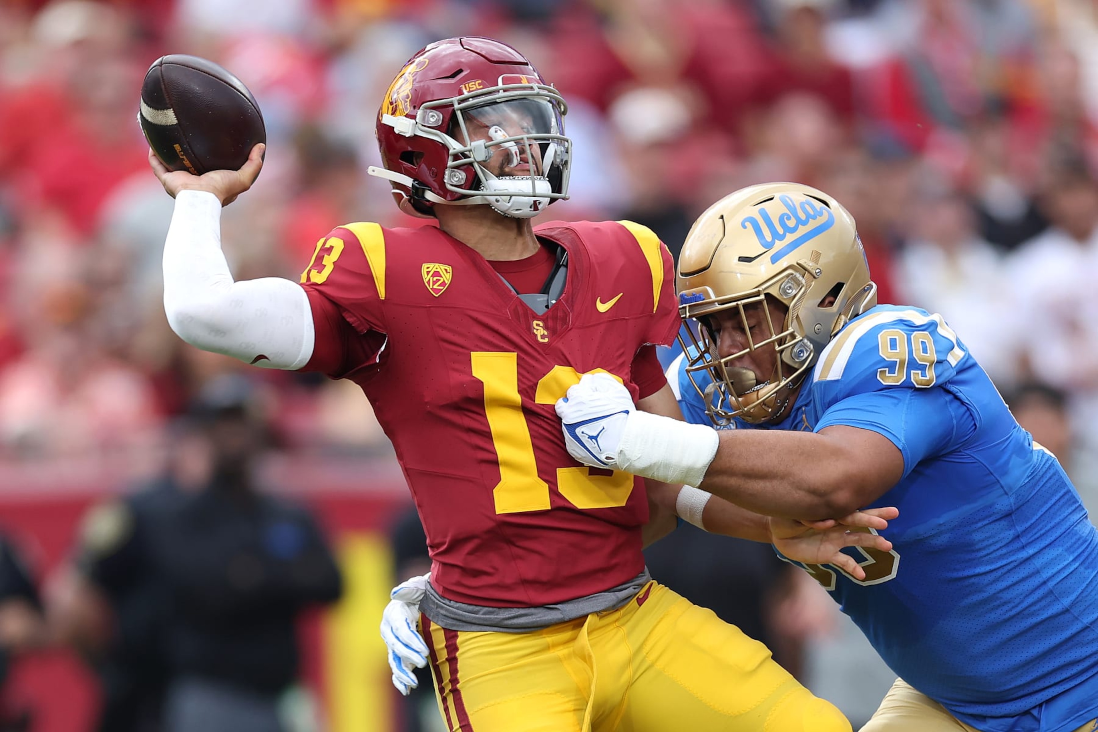 LOS ANGELES, CALIFORNIA - NOVEMBER 18: Keanu Williams #99 of the UCLA Bruins pressures Caleb Williams #13 of the USC Trojans during the first half of a game against the UCLA Bruins at United Airlines Field at the Los Angeles Memorial Coliseum on November 18, 2023 in Los Angeles, California. (Photo by Sean M. Haffey/Getty Images)