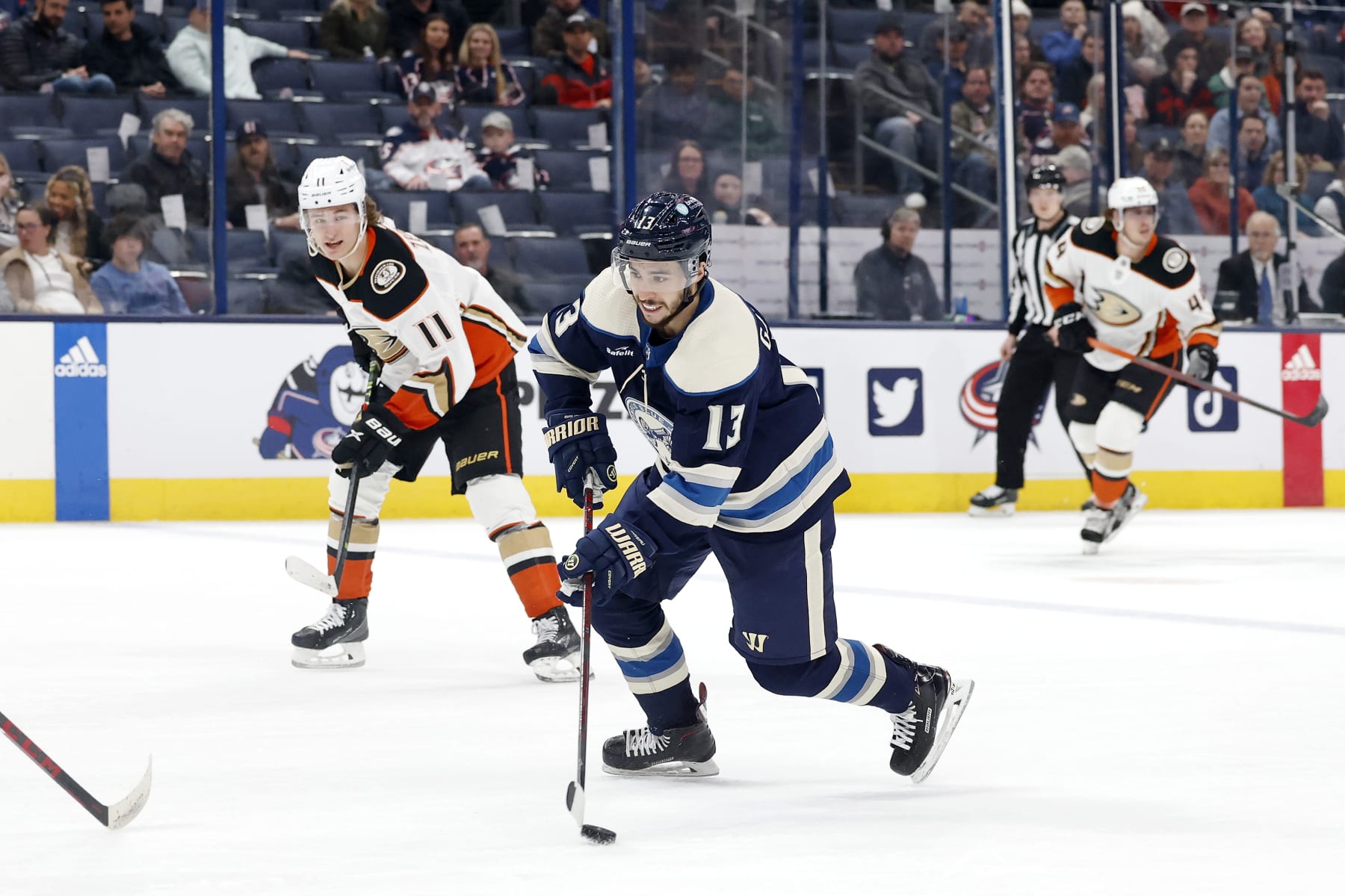 Columbus Blue Jackets winger Johnny Gaudreau (center) and Anaheim Ducks center Trevor Zegras (left). 