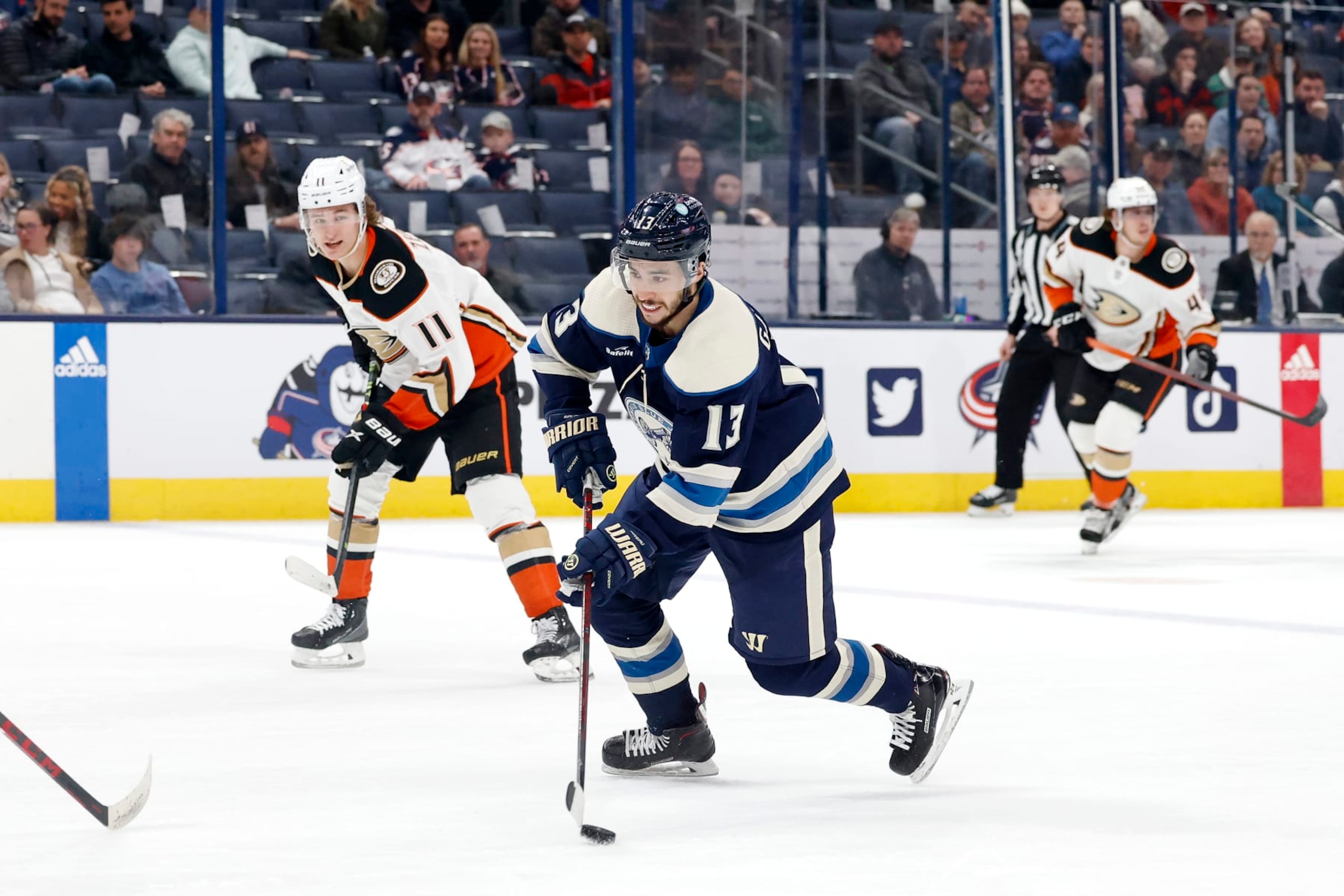 Columbus Blue Jackets winger Johnny Gaudreau (center) and Anaheim Ducks center Trevor Zegras (left). 