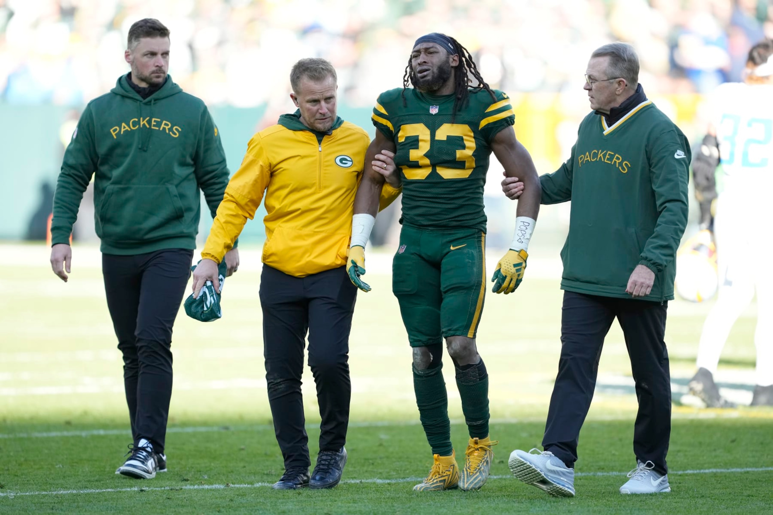 GREEN BAY, WISCONSIN - NOVEMBER 19: Aaron Jones #33 of the Green Bay Packers is helped off the field after being injured in the second quarter against the Los Angeles Chargers at Lambeau Field on November 19, 2023 in Green Bay, Wisconsin. (Photo by Patrick McDermott/Getty Images)