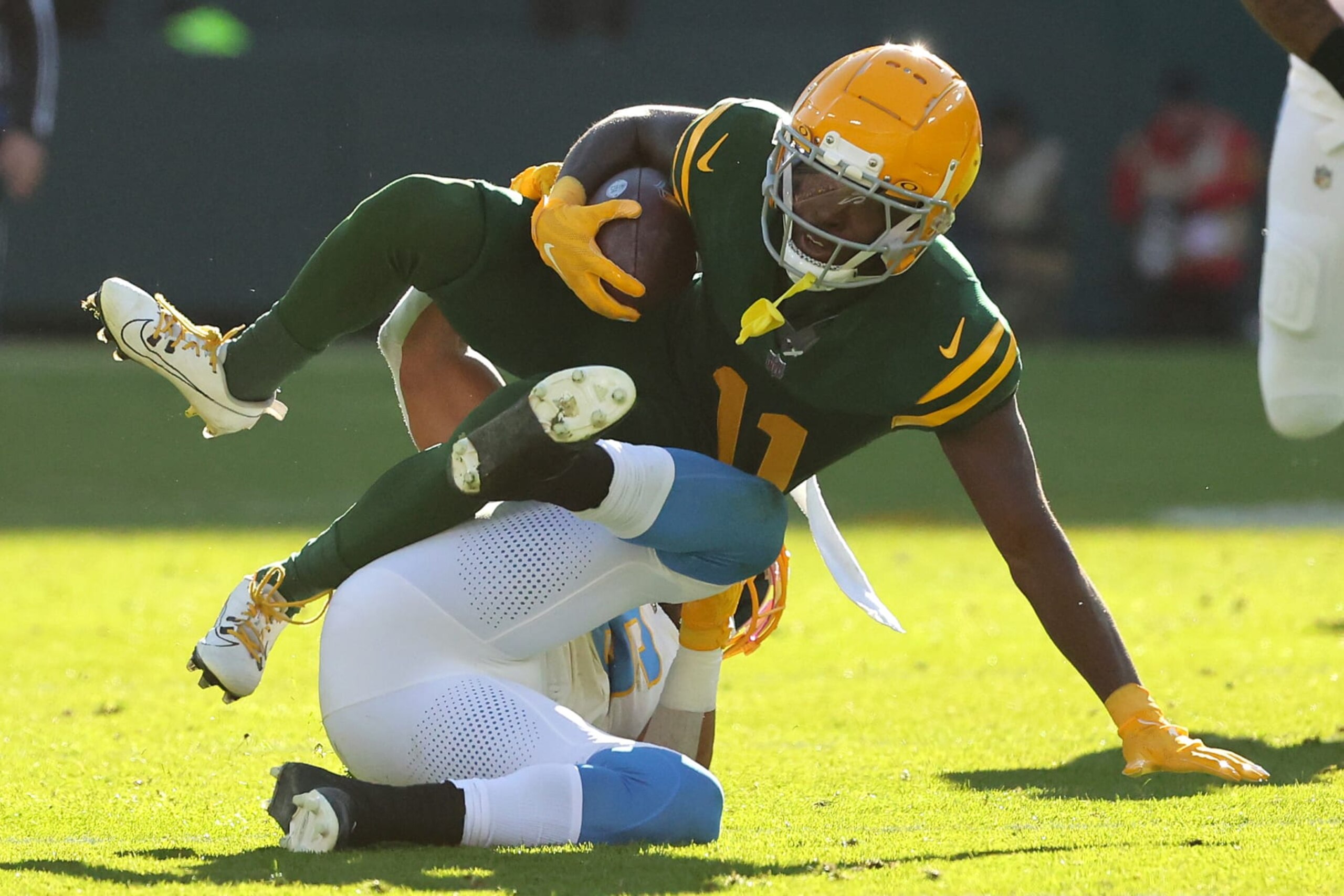 GREEN BAY, WISCONSIN - NOVEMBER 19: Jayden Reed #11 of the Green Bay Packers runs with the ball while being tackled by Eric Kendricks #6 of the Los Angeles Chargers in the second quarter at Lambeau Field on November 19, 2023 in Green Bay, Wisconsin. (Photo by Stacy Revere/Getty Images)