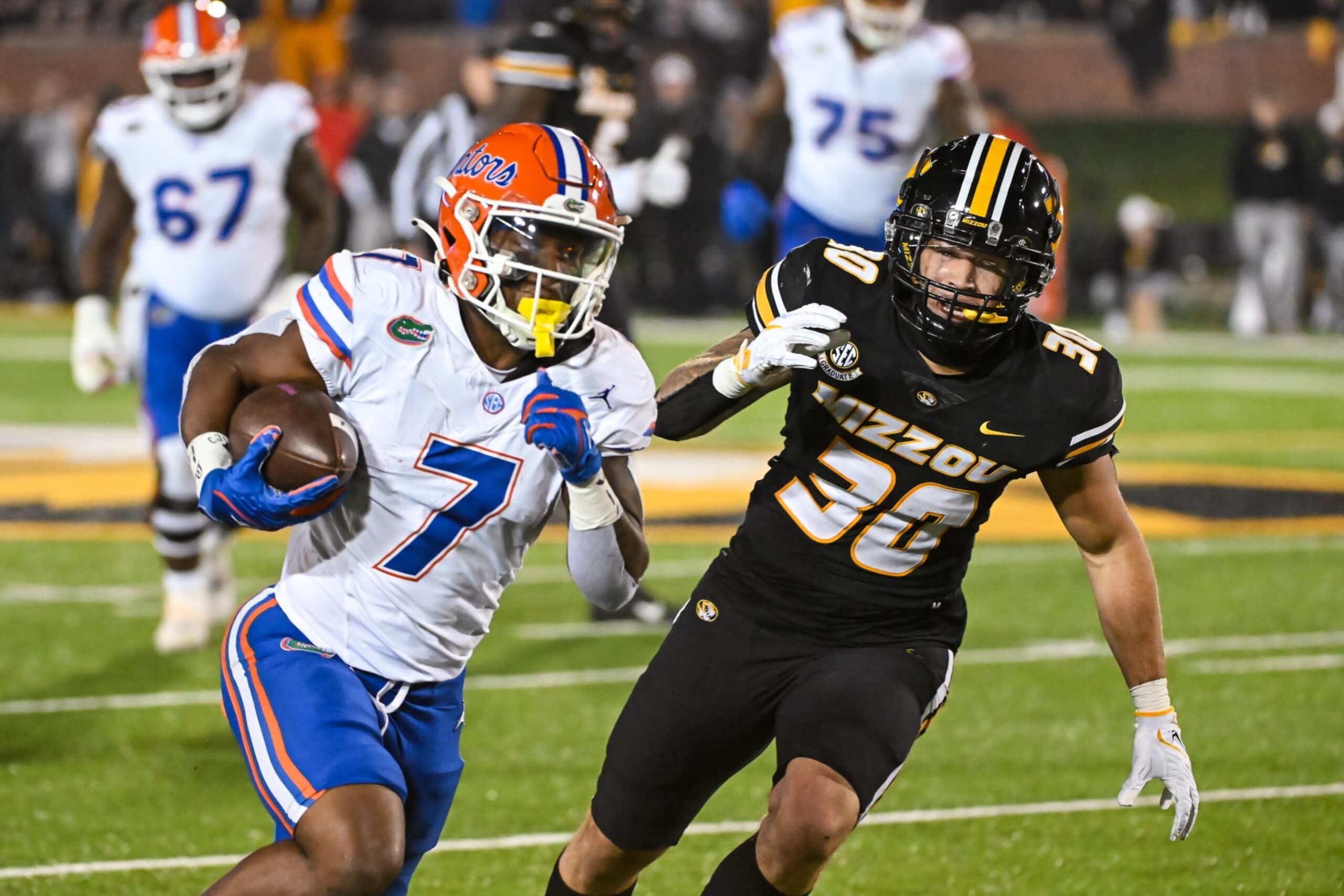 COLUMBIA, MO - NOVEMBER 18: Florida Gators running back Trevor Etienne (7) gets past the defense of Missouri Tigers linebacker Chuck Hicks (30) on his way to score a touchdown during a SEC conference game between the Florida Gators and the Missouri Tigers held on Saturday Nov 18, 2023 at Faurot Field at Memorial Stadium in Columbia MO. (Photo by Rick Ulreich/Icon Sportswire via Getty Images