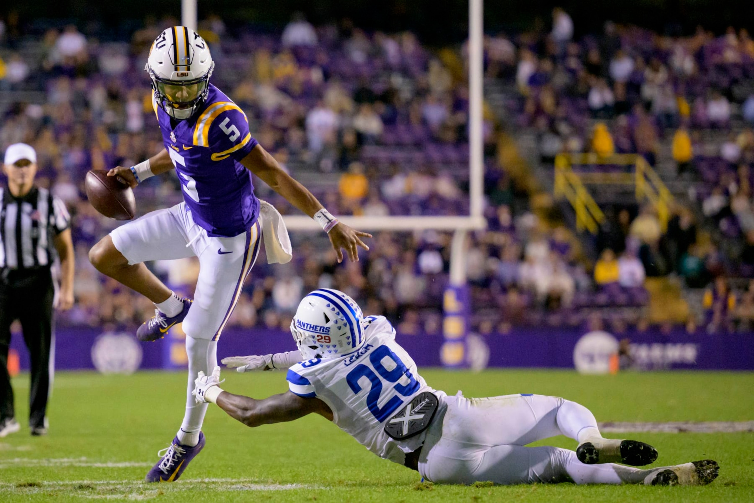 LSU quarterback Jayden Daniels (5) runs against Georgia State safety TyGee Leach (29) during the second half of an NCAA college football game in Baton Rouge, La., Saturday, Nov. 18, 2023. (AP Photo/Matthew Hinton)