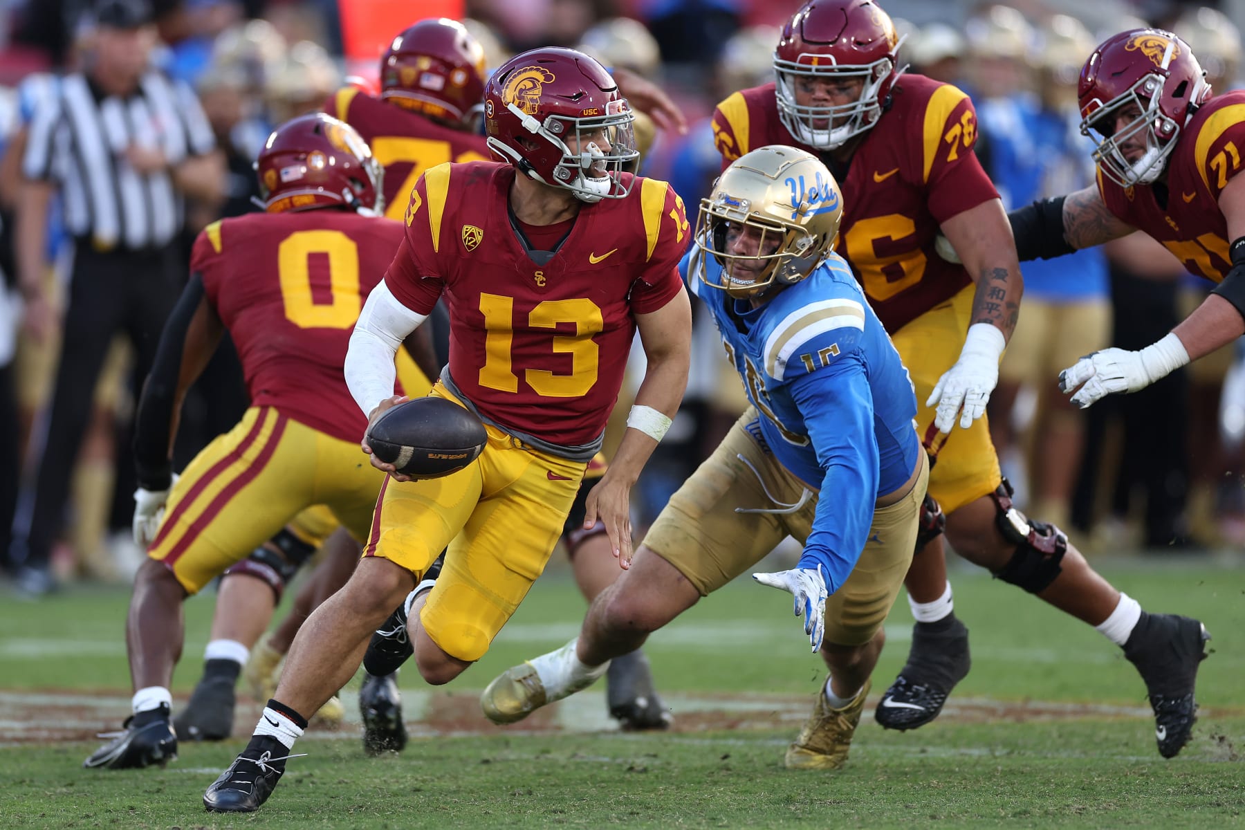 LOS ANGELES, CALIFORNIA - NOVEMBER 18: Caleb Williams #13 of the USC Trojans is flushed from the pocket by Laiatu Latu #15 of the UCLA Bruins during the second half of a game at United Airlines Field at the Los Angeles Memorial Coliseum on November 18, 2023 in Los Angeles, California. (Photo by Sean M. Haffey/Getty Images)