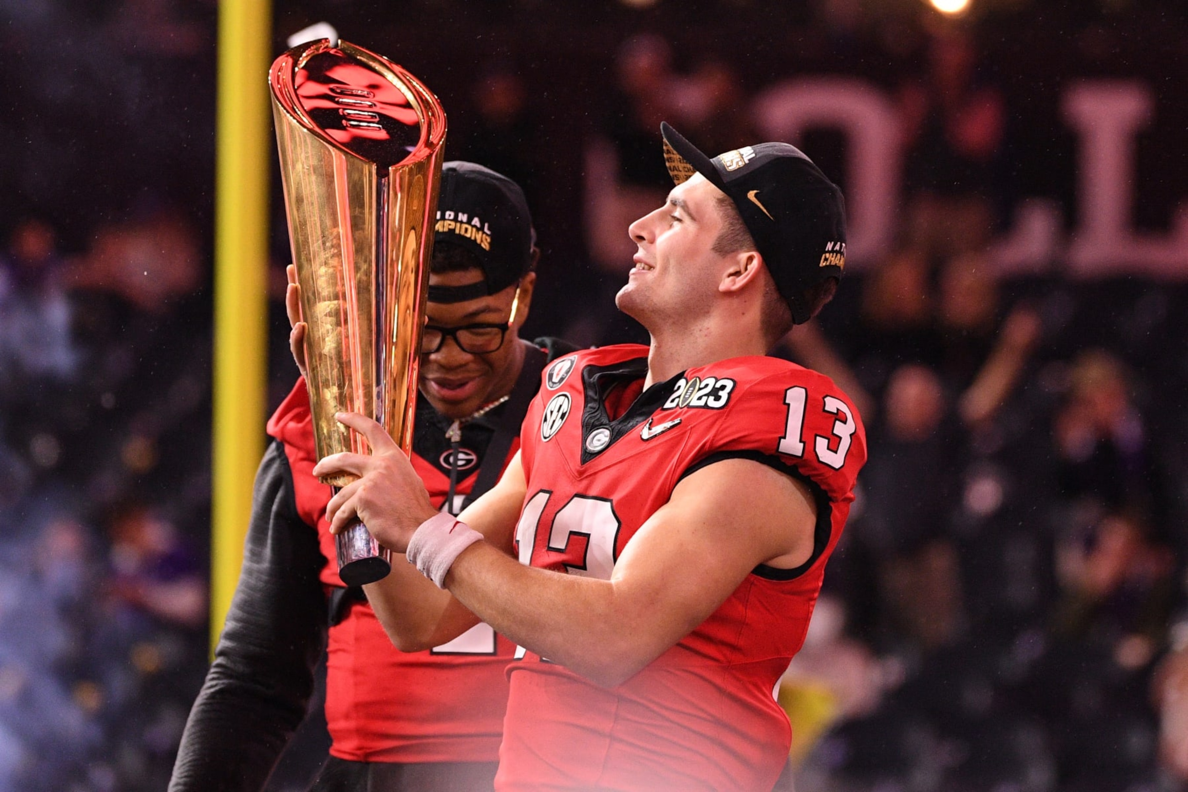 INGLEWOOD, CA - JANUARY 09: Georgia Bulldogs quarterback Stetson Bennett (13) holds up the trophy after the Georgia Bulldogs game versus the TCU Horned Frogs in the College Football Playoff National Championship game on January 9, 2023, at SoFi Stadium in Inglewood, CA. (Photo by Brian Rothmuller/Icon Sportswire via Getty Images)