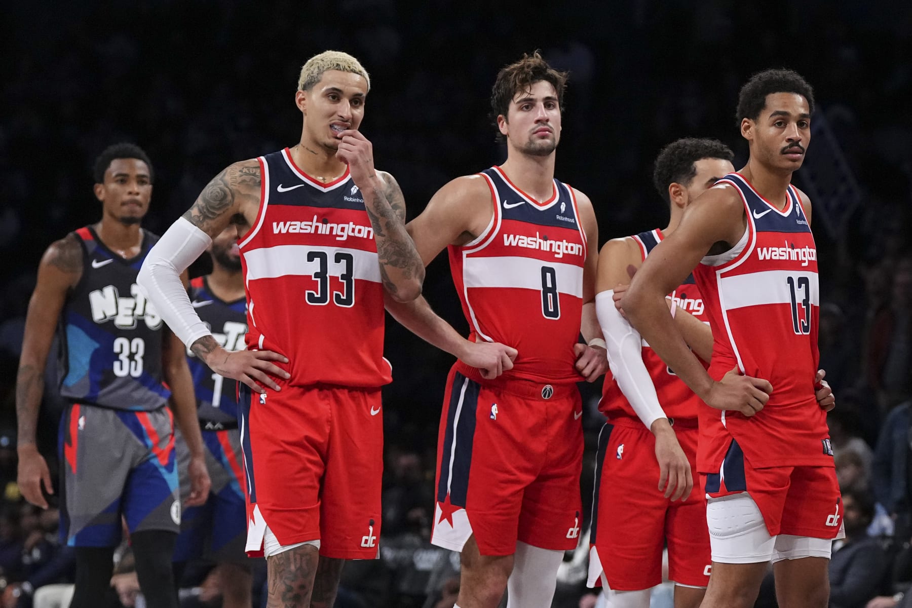 NEW YORK, NEW YORK - NOVEMBER 12: Kyle Kuzma #33, Deni Avdija #8, Tyus Jones #5, and Jordan Poole #13 of the Washington Wizards look on against the Brooklyn Nets at Barclays Center on November 12, 2023 in the Brooklyn borough of New York City. The Nets defeated the Wizards 102-94. NOTE TO USER: User expressly acknowledges and agrees that, by downloading and or using this photograph, User is consenting to the terms and conditions of the Getty Images License Agreement. (Photo by Mitchell Leff/Getty Images)