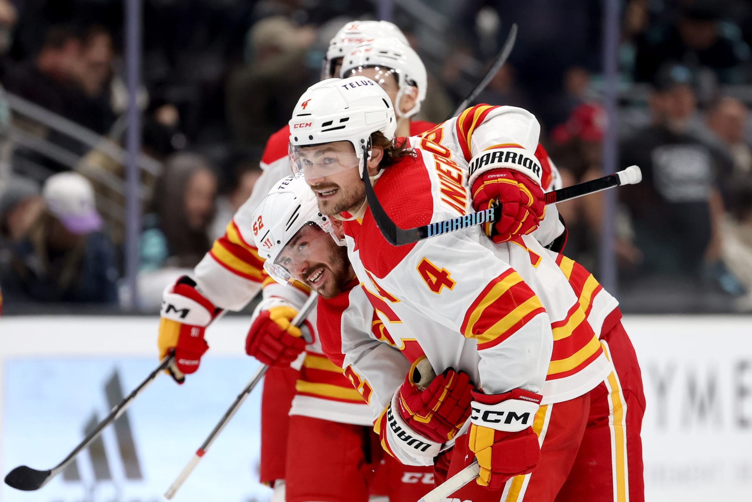 SEATTLE, WASHINGTON - NOVEMBER 20: Rasmus Andersson #4 of the Calgary Flames celebrates his game-winning goal in overtime with MacKenzie Weegar #52 of the Calgary Flames against the Seattle Kraken at Climate Pledge Arena on November 20, 2023 in Seattle, Washington. (Photo by Steph Chambers/Getty Images)